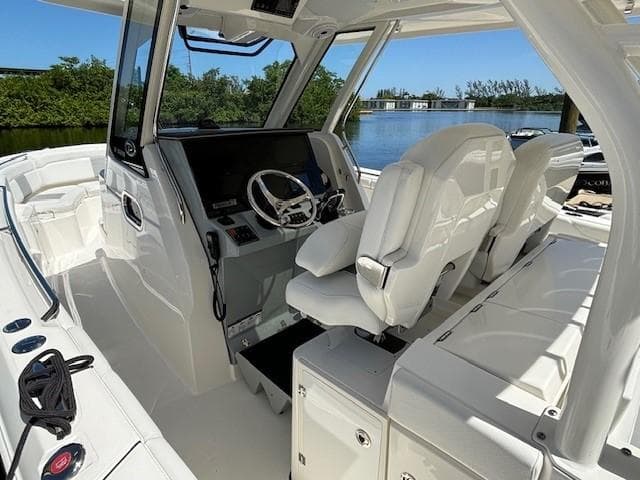 2020 Pursuit S 328 Sport boat interior with helm, white seating, and water view.