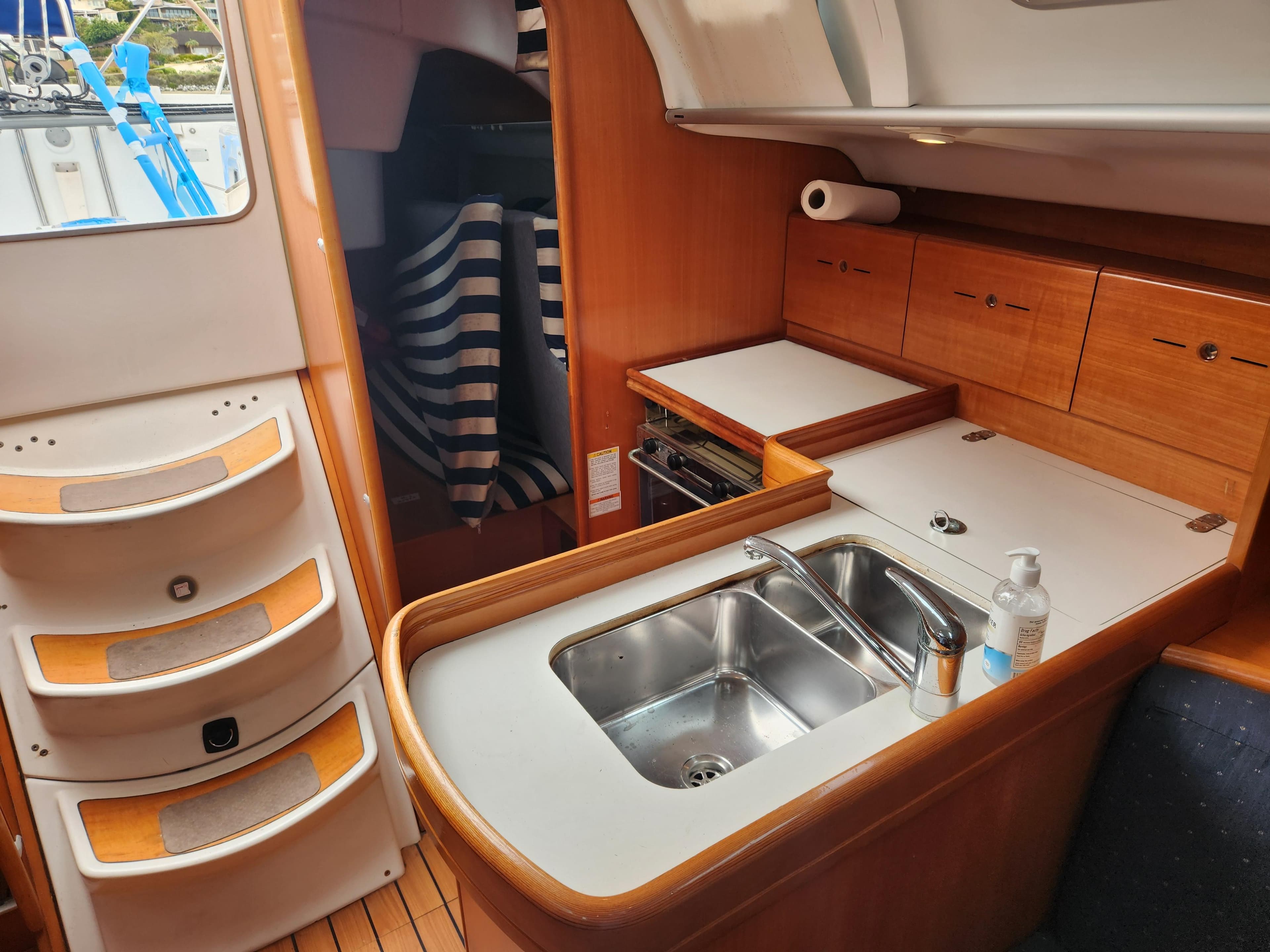 Interior of 2003 Beneteau First 40.7 yacht, featuring a compact kitchen with sink and storage.