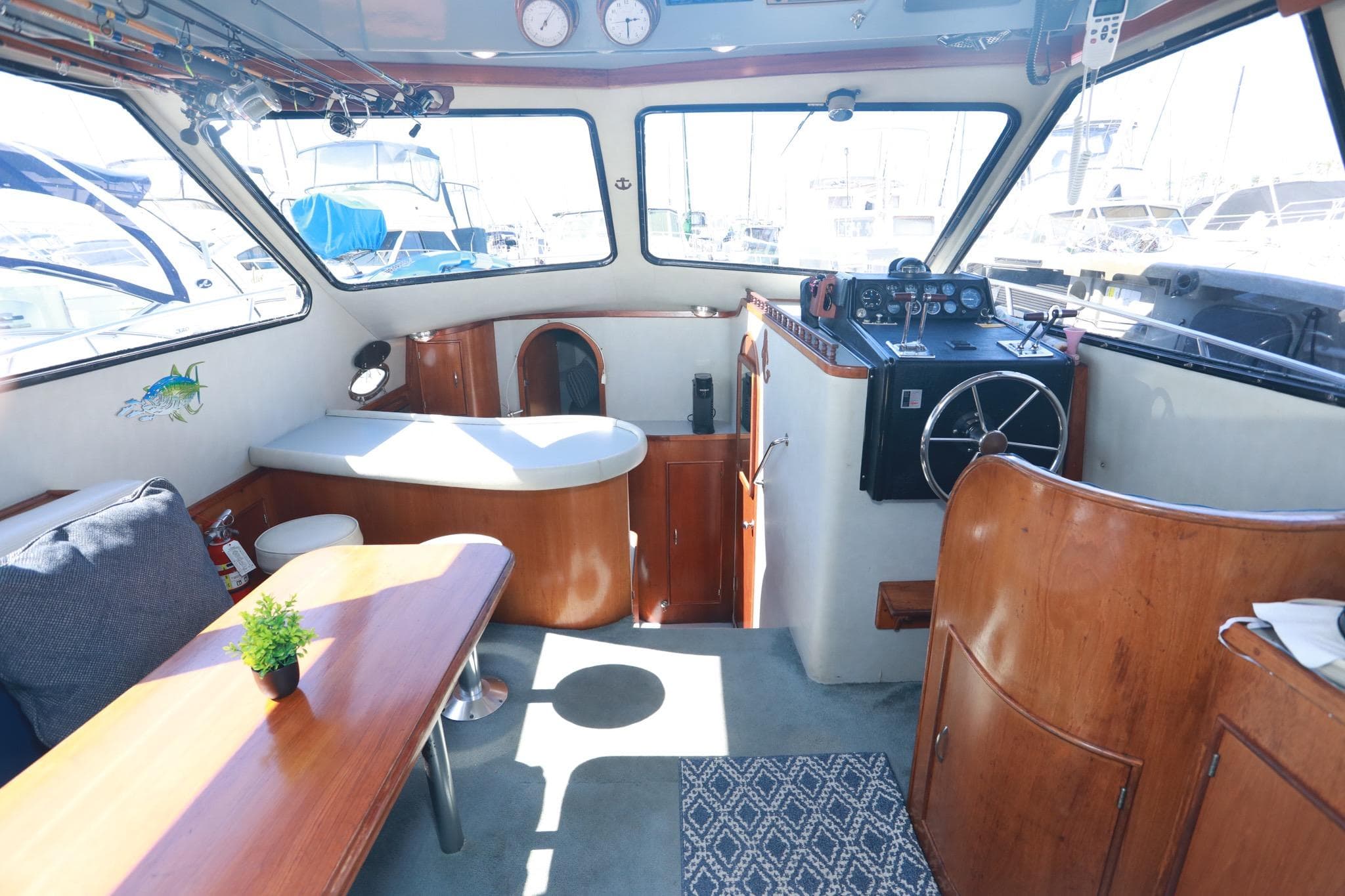 Interior of a 1988 Mediterranean 38 Convertible yacht with wooden furnishings and helm.