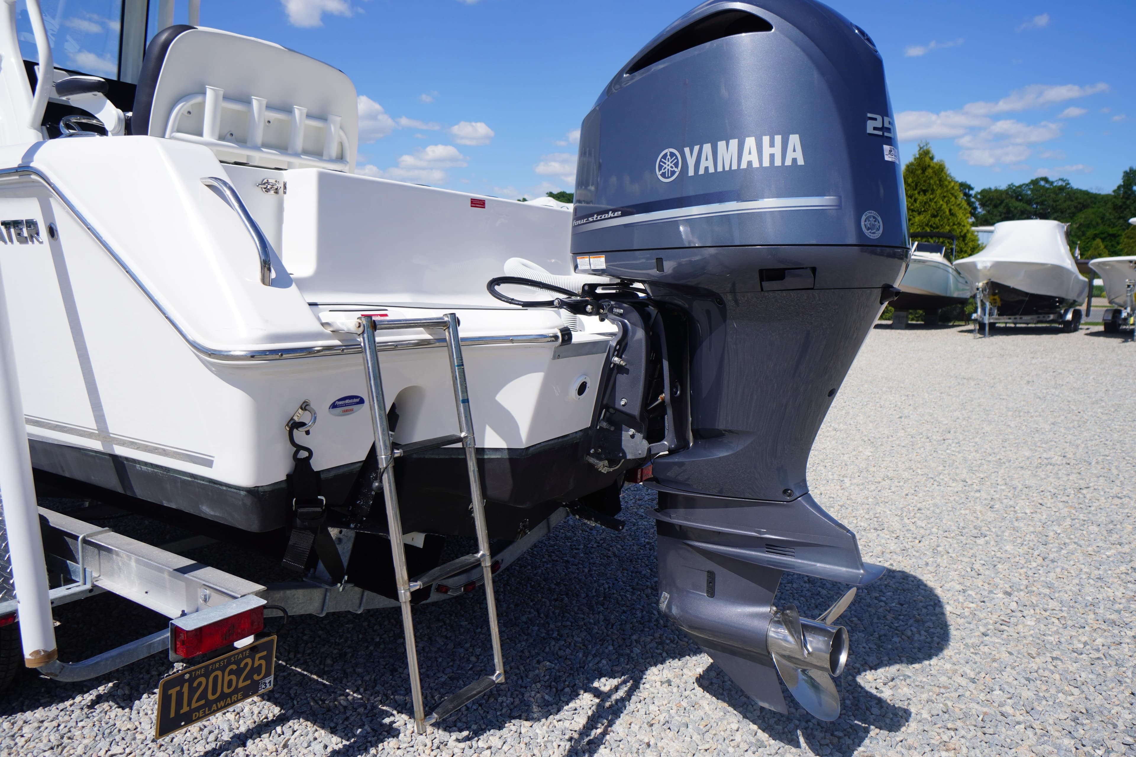 2024 Tidewater 232 CC Adventure boat with Yamaha outboard motor, parked on gravel.