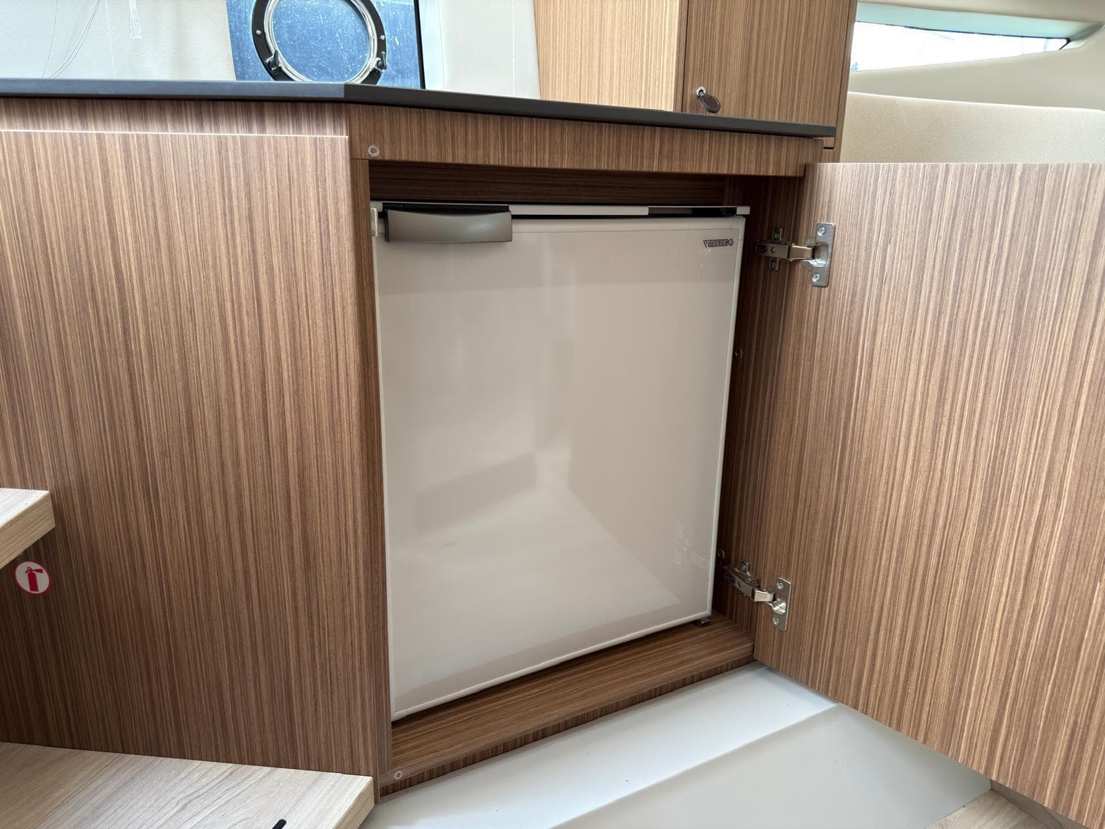 2024 FIM 340 yacht interior with a built-in compact refrigerator.
