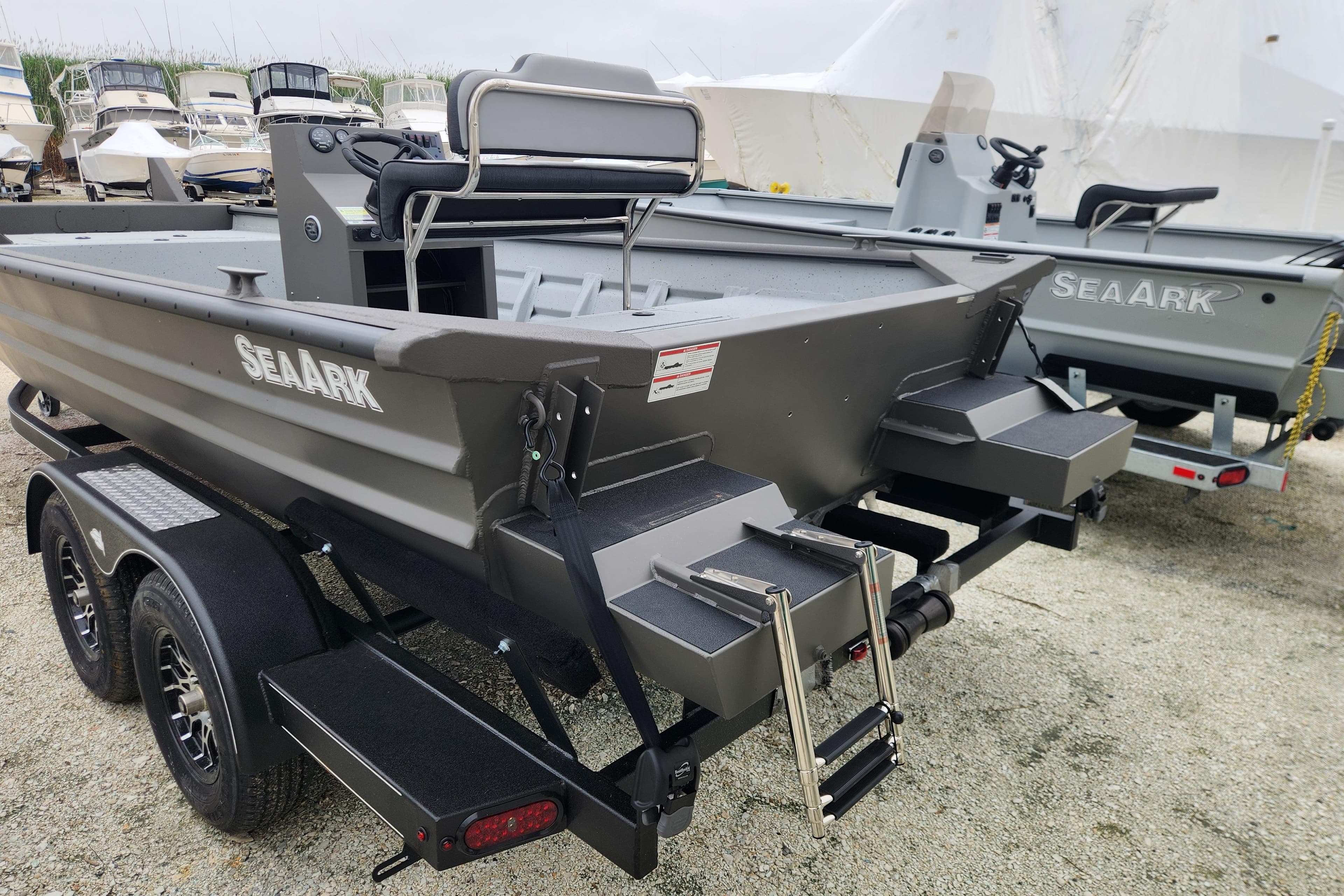 2025 SeaArk 2072 Workhorse boat on trailer, featuring dual axles and rear ladder.