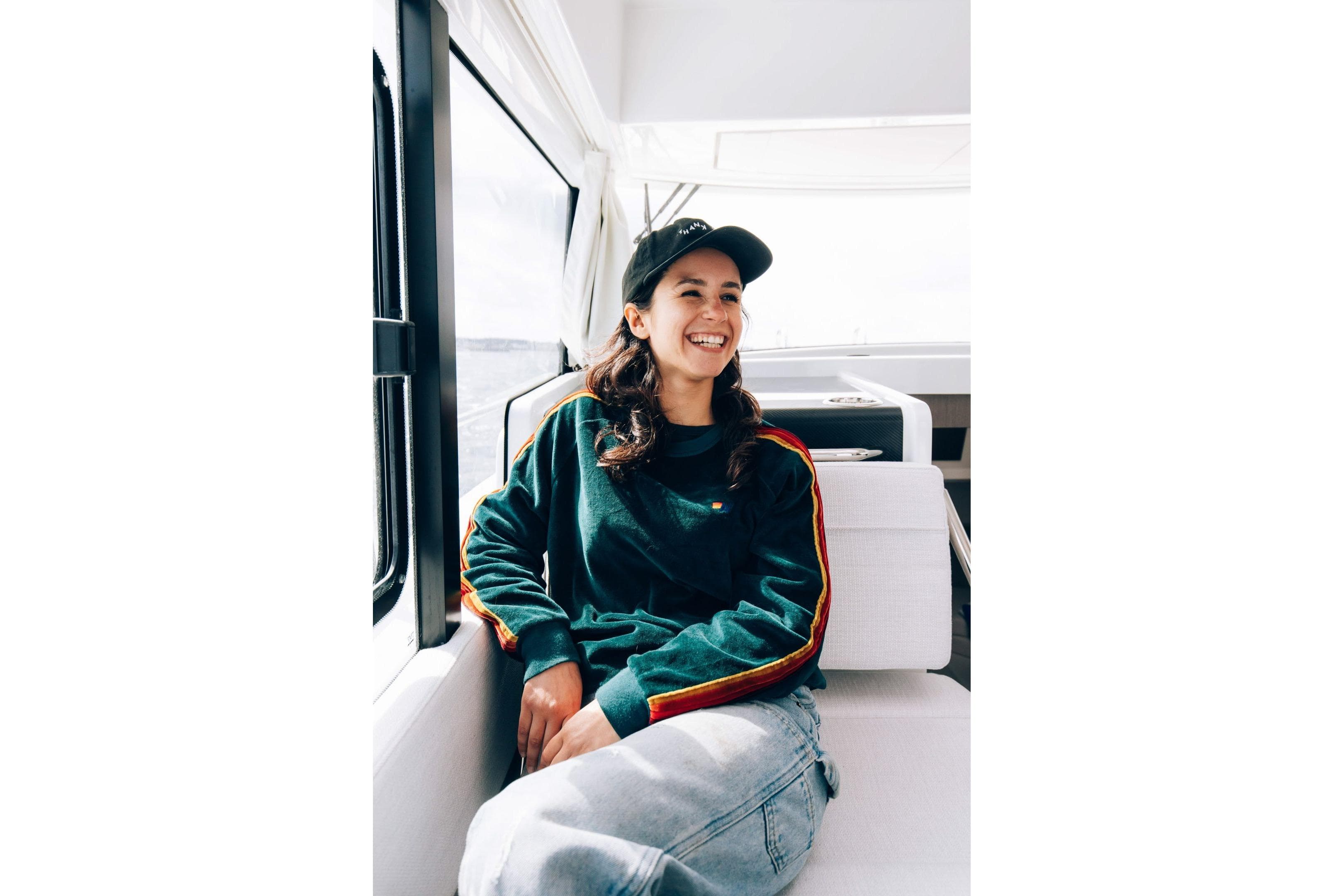 Smiling person relaxing on a 2026 Jeanneau NC 895 Sport Series 2 boat interior.