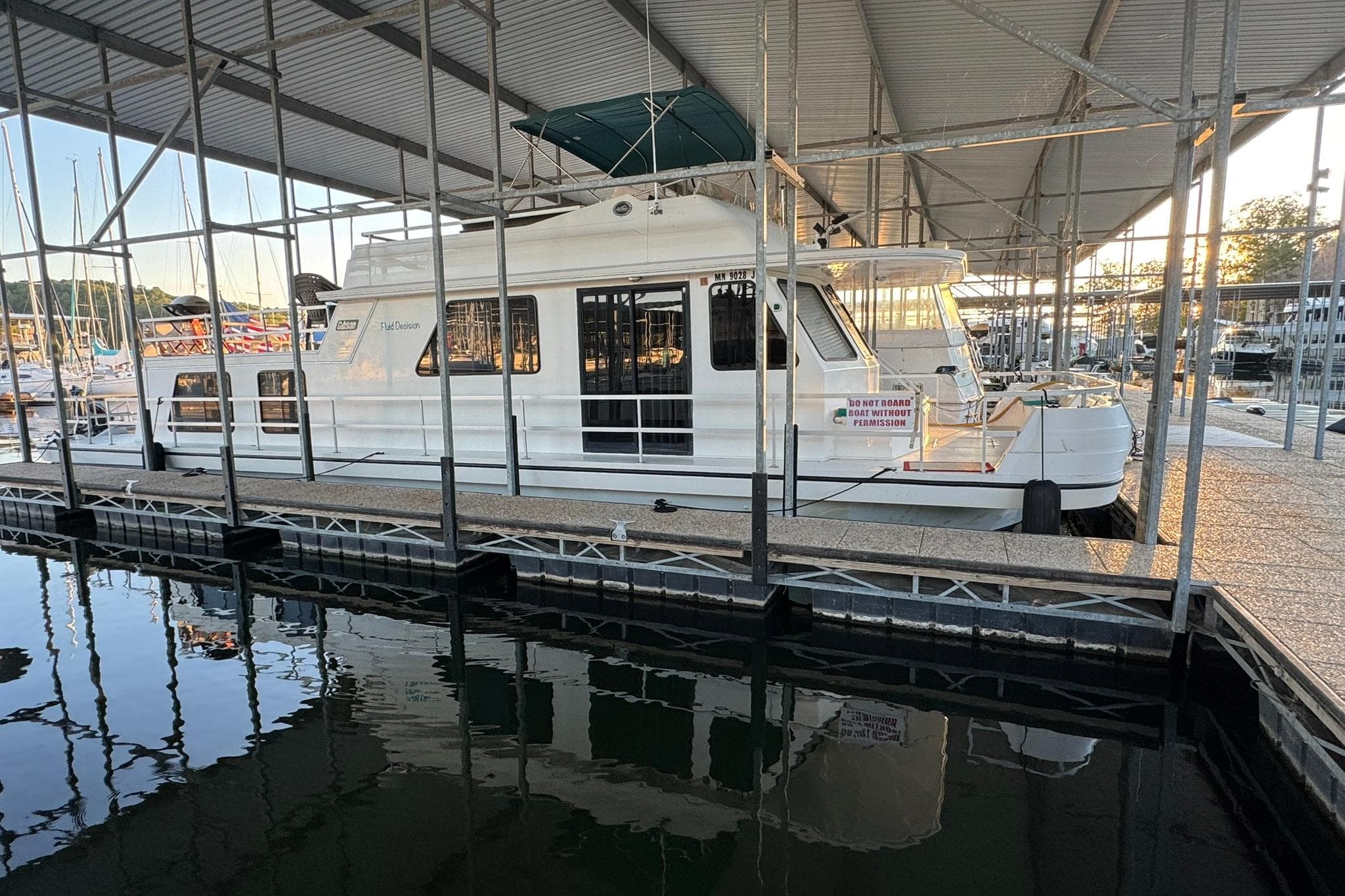 1996 Gibson 50 Cabin Yacht docked in a marina under a covered structure.