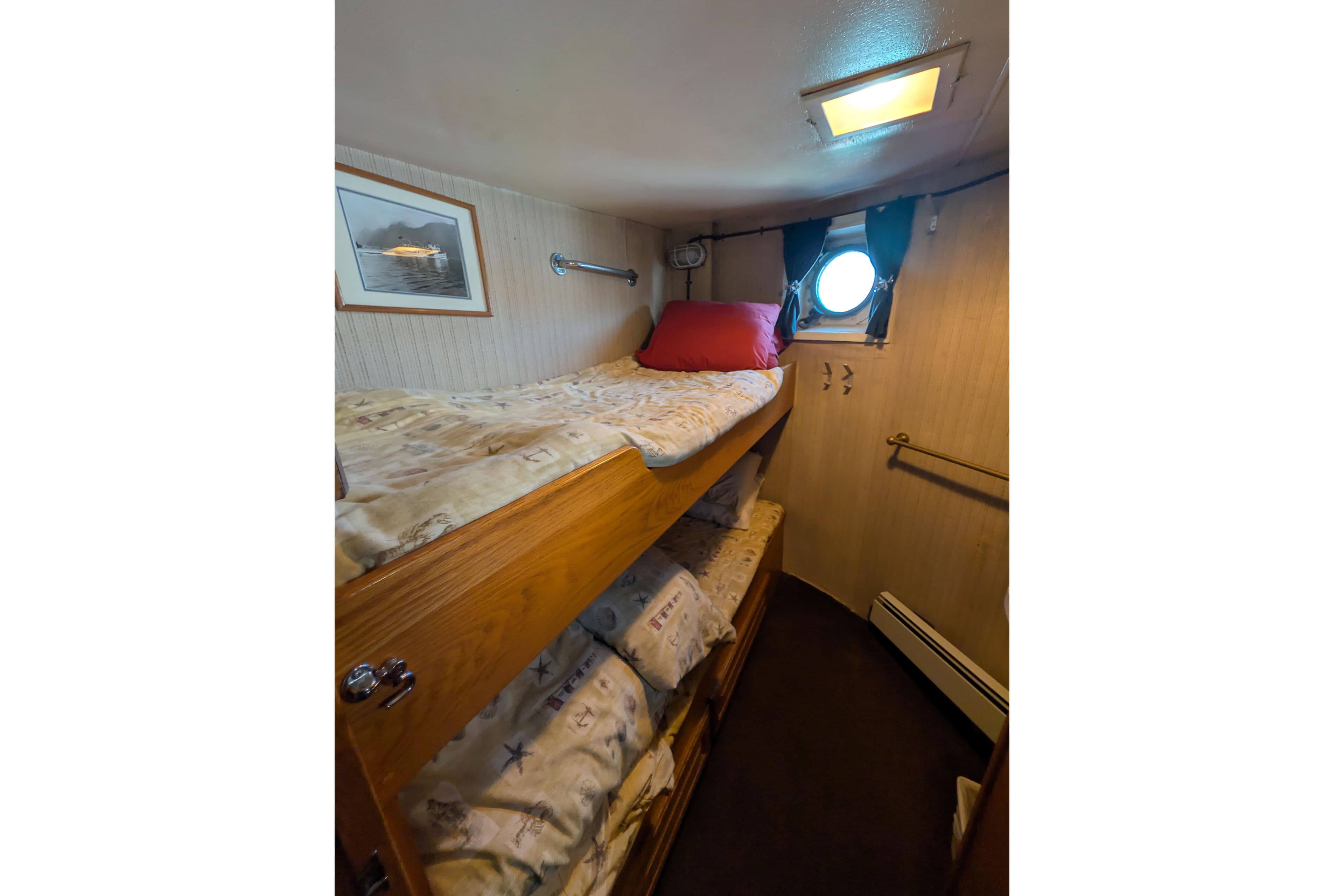 Cozy cabin interior of 1941 Armstrong Marine Custom Wooden Trawler Charter Vessel with bunk beds.