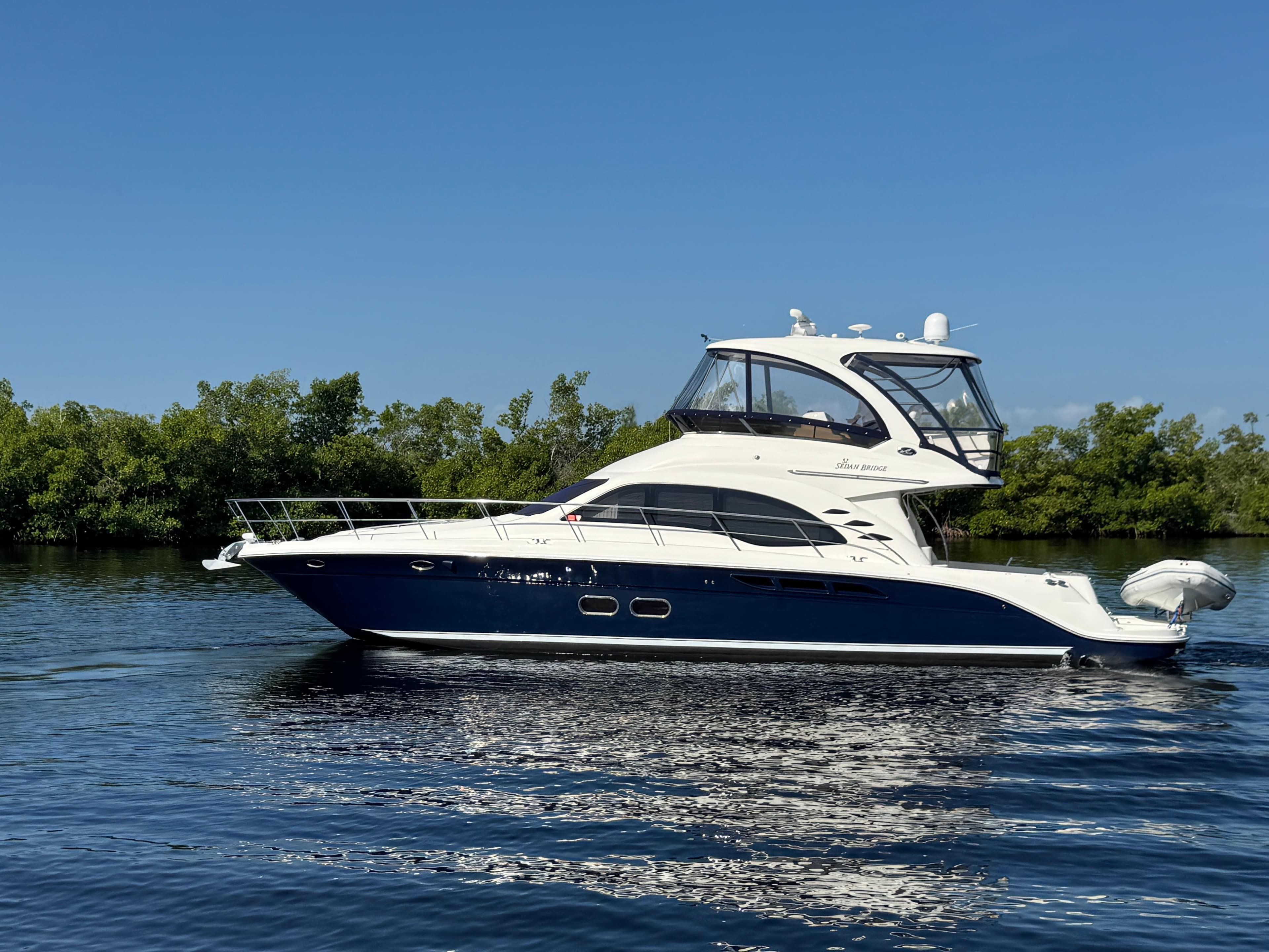 2007 Sea Ray 52 Sedan Bridge yacht on calm water, clear sky background.