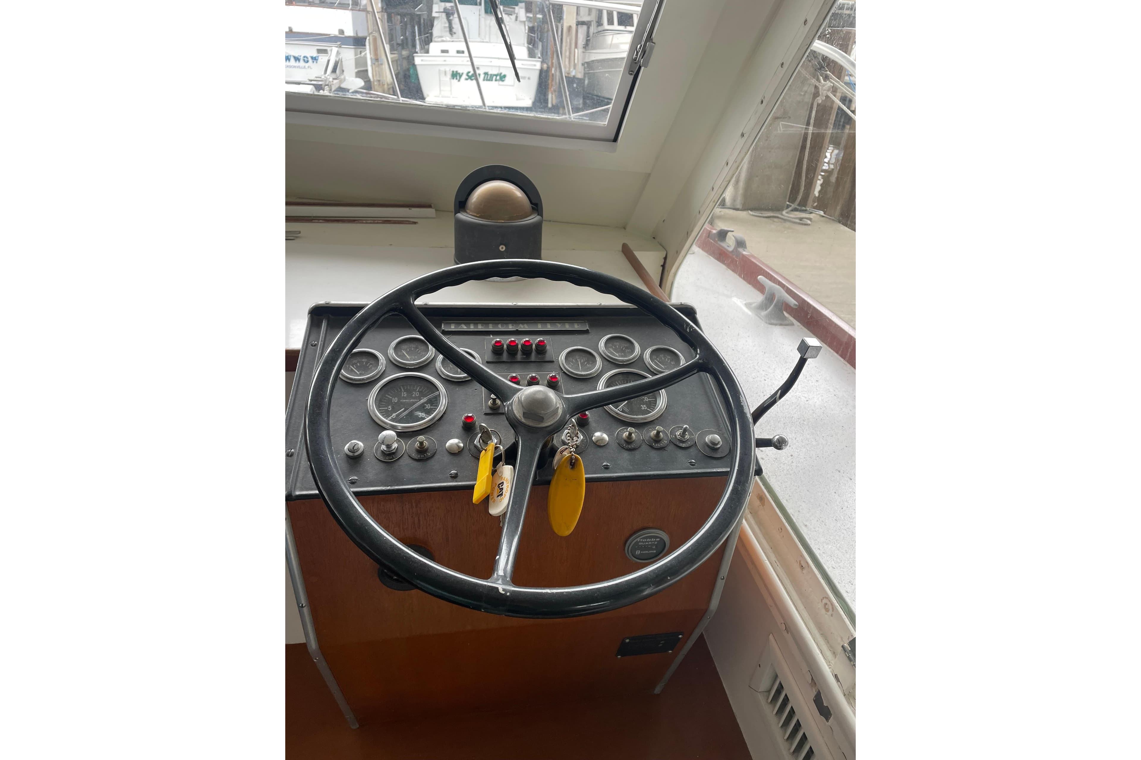 1958 Huckins Seafarer helm with vintage steering wheel and instrument panel.