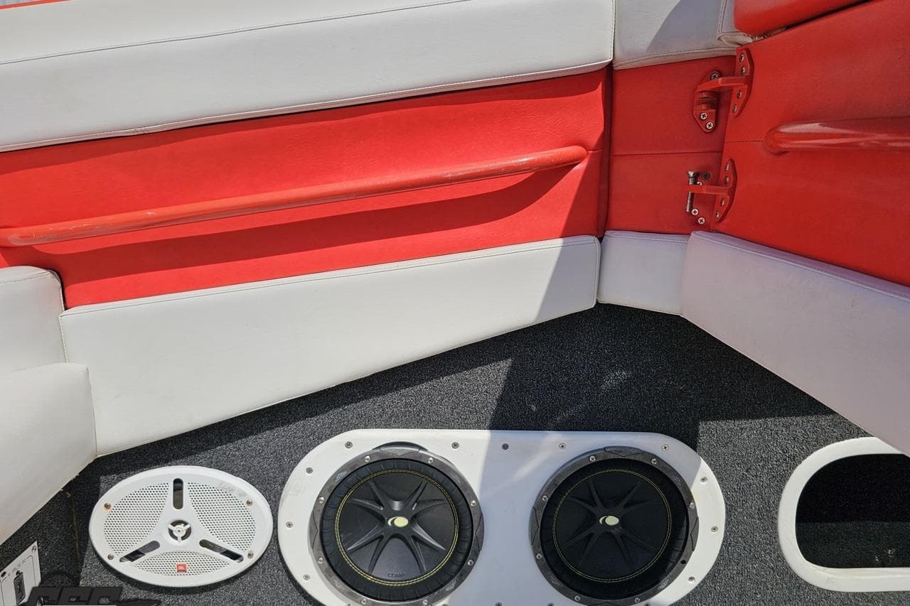 Interior of 1995 Hustler 40 Fiore boat with red and white seating, speakers visible.