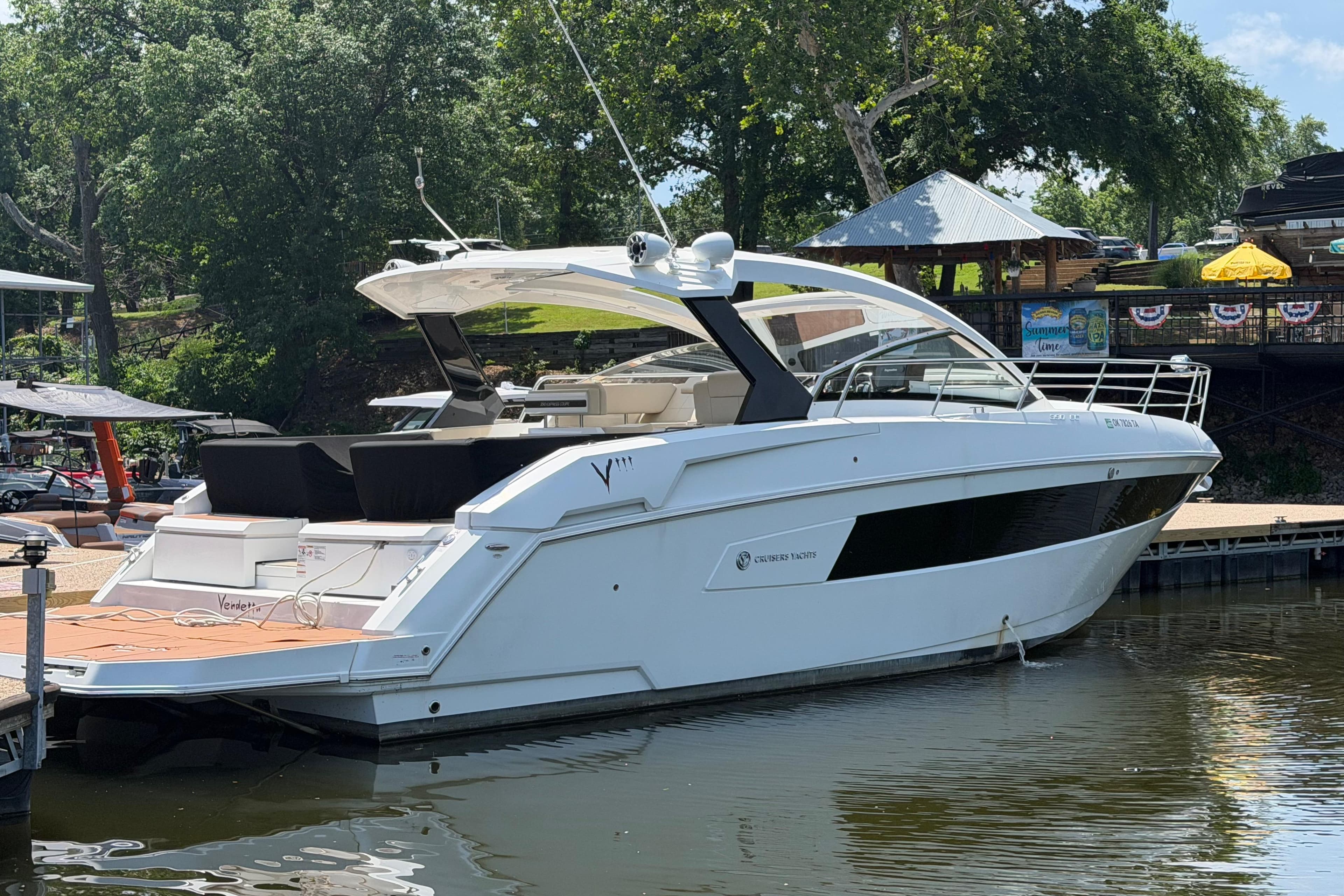2019 Cruisers Yachts 390 Express Coupe docked by a scenic waterfront.