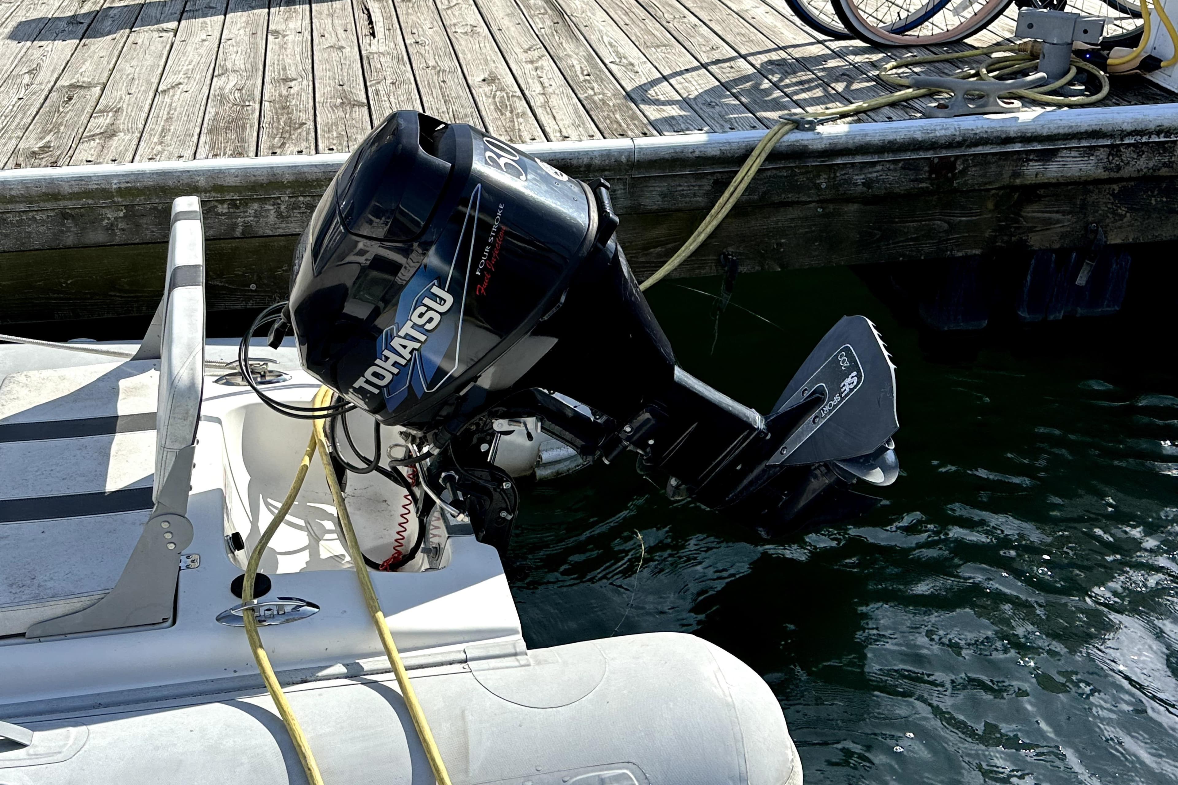 Outboard motor on a 2003 Donzi 39 ZSC boat docked by wooden pier.