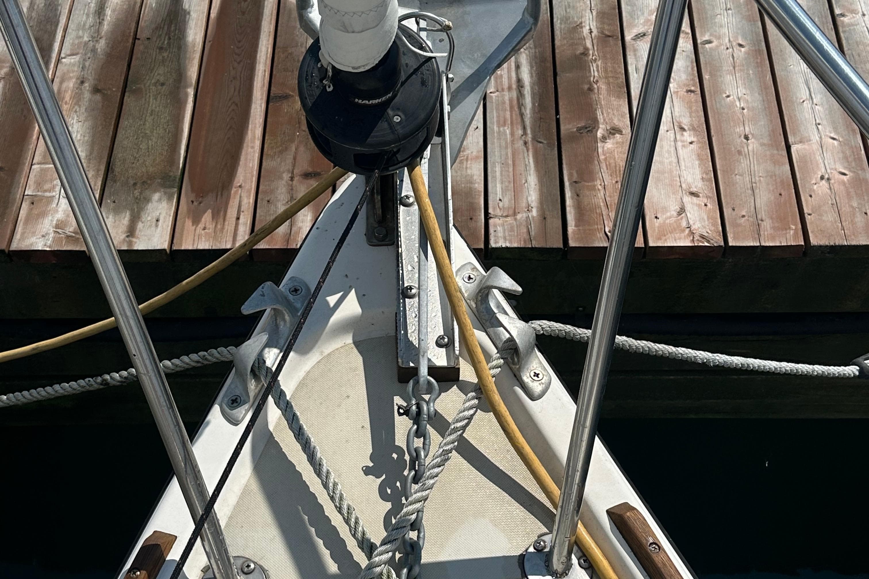 Bow of 1984 Pearson 34 sailboat docked, showing ropes and anchor equipment.