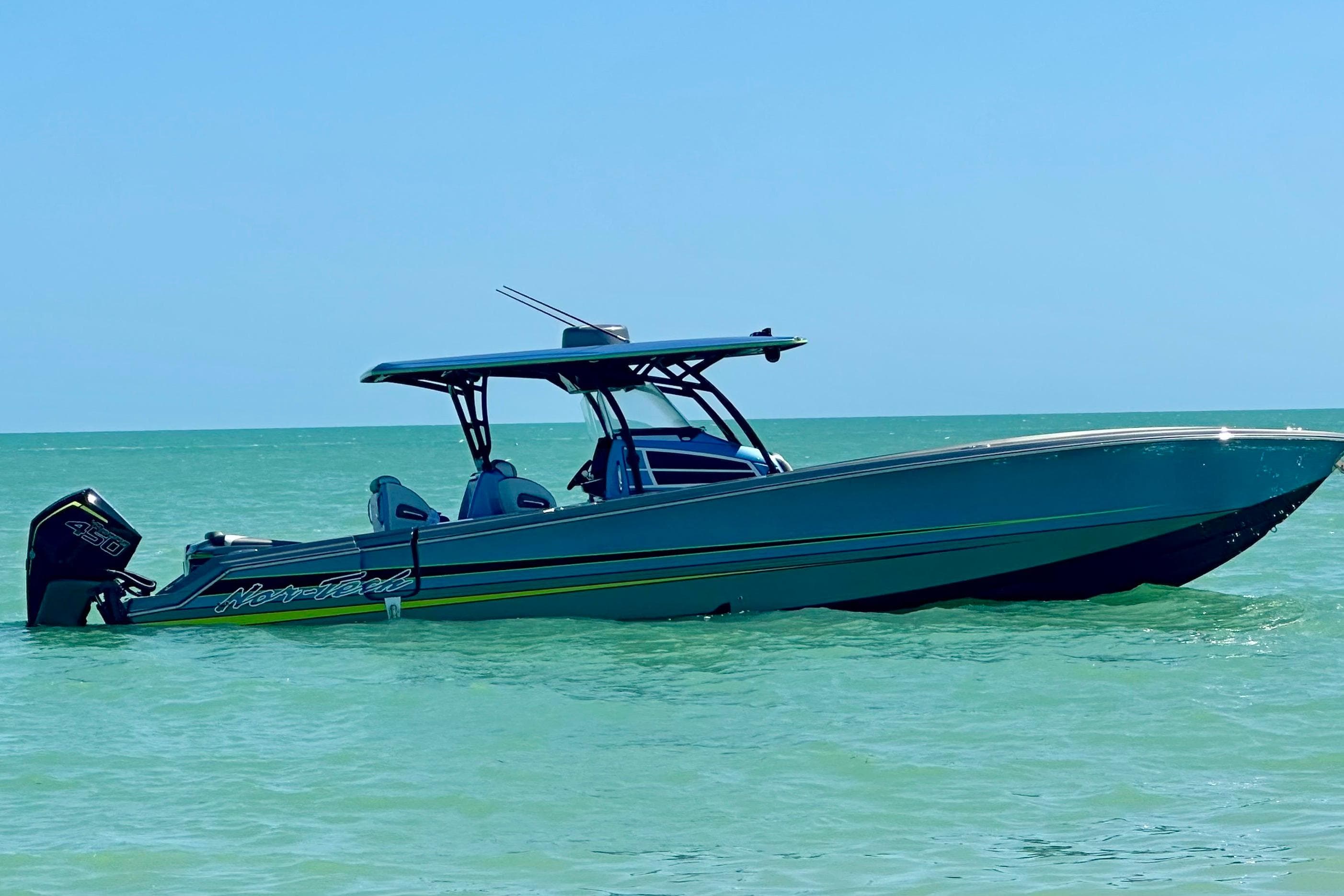 2023 Nor-Tech 390 Sport Center Console boat on calm turquoise water.