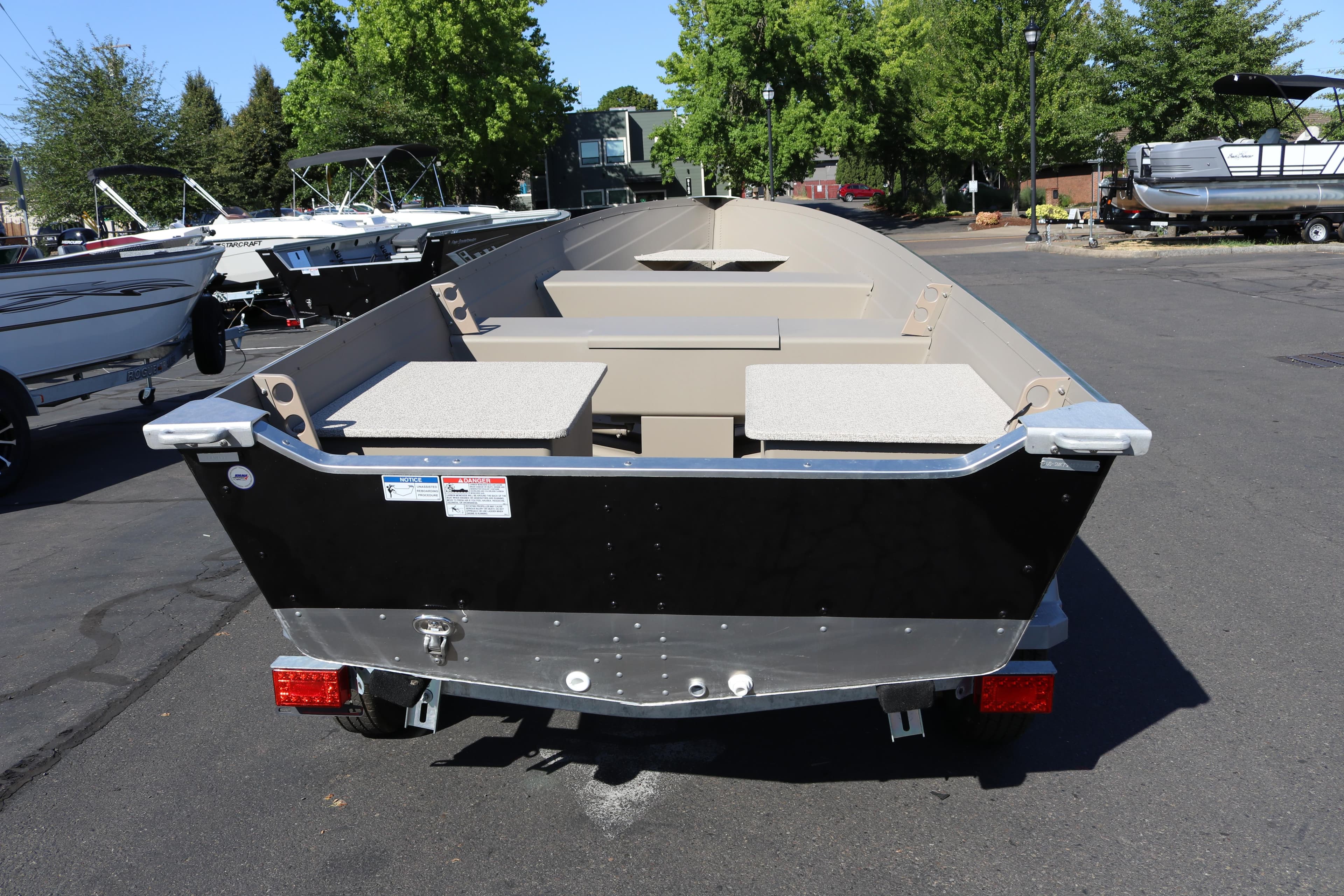 2025 Smoker Craft Voyager 16 boat on trailer, parked outdoors.