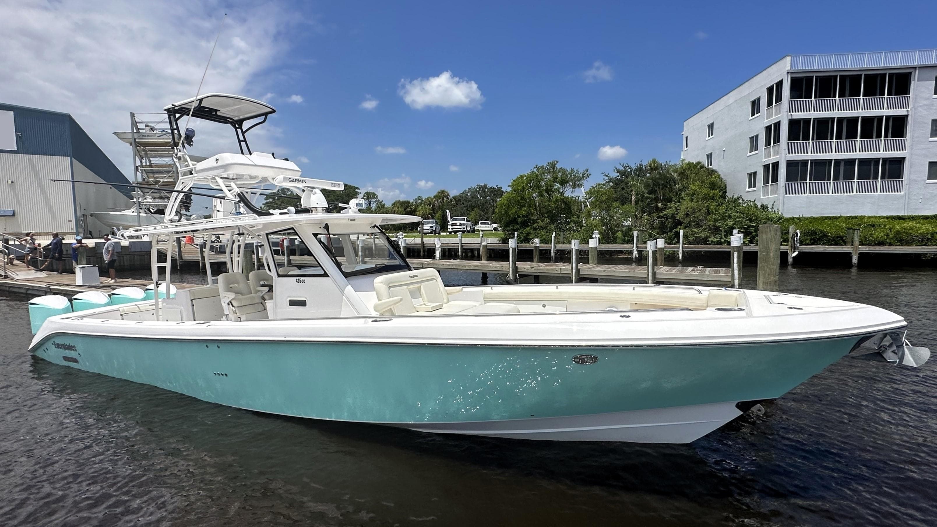 2017 Everglades 435 Center Console boat docked near modern buildings.