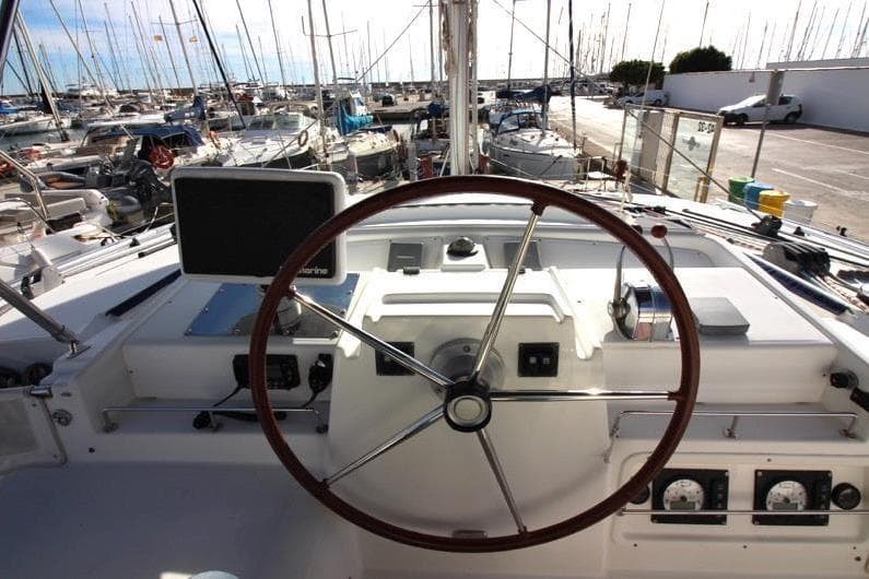 Steering wheel of 2009 Lagoon 440 catamaran docked at marina.