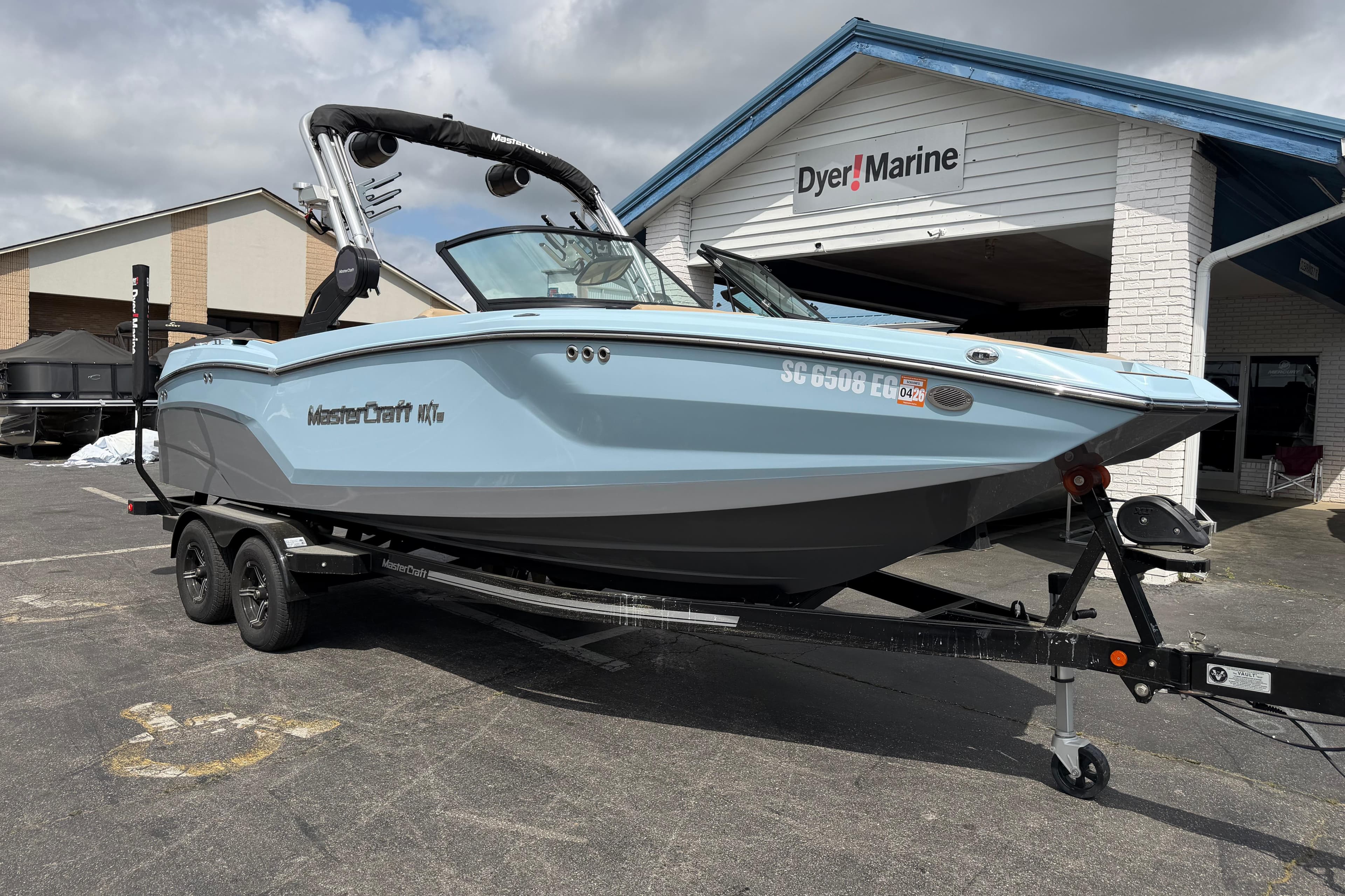 2025 MasterCraft NXT22 boat on trailer outside Dyer Marine dealership.