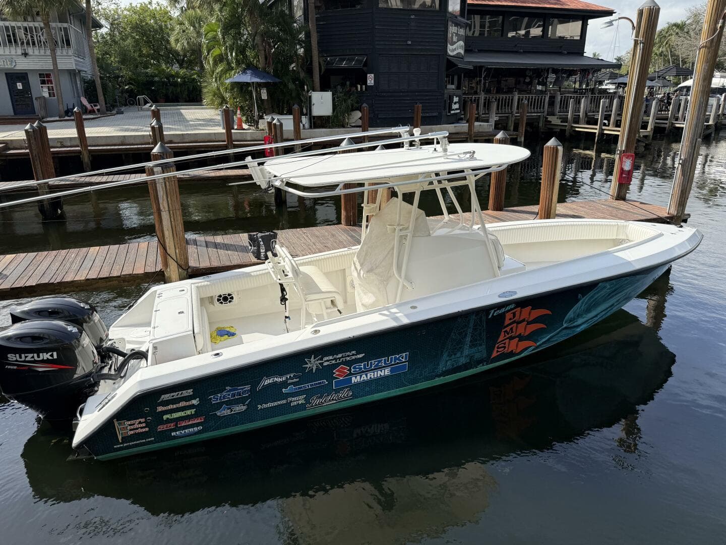 2002 Jupiter 27 Open boat docked, featuring Suzuki outboard motor and custom graphics.