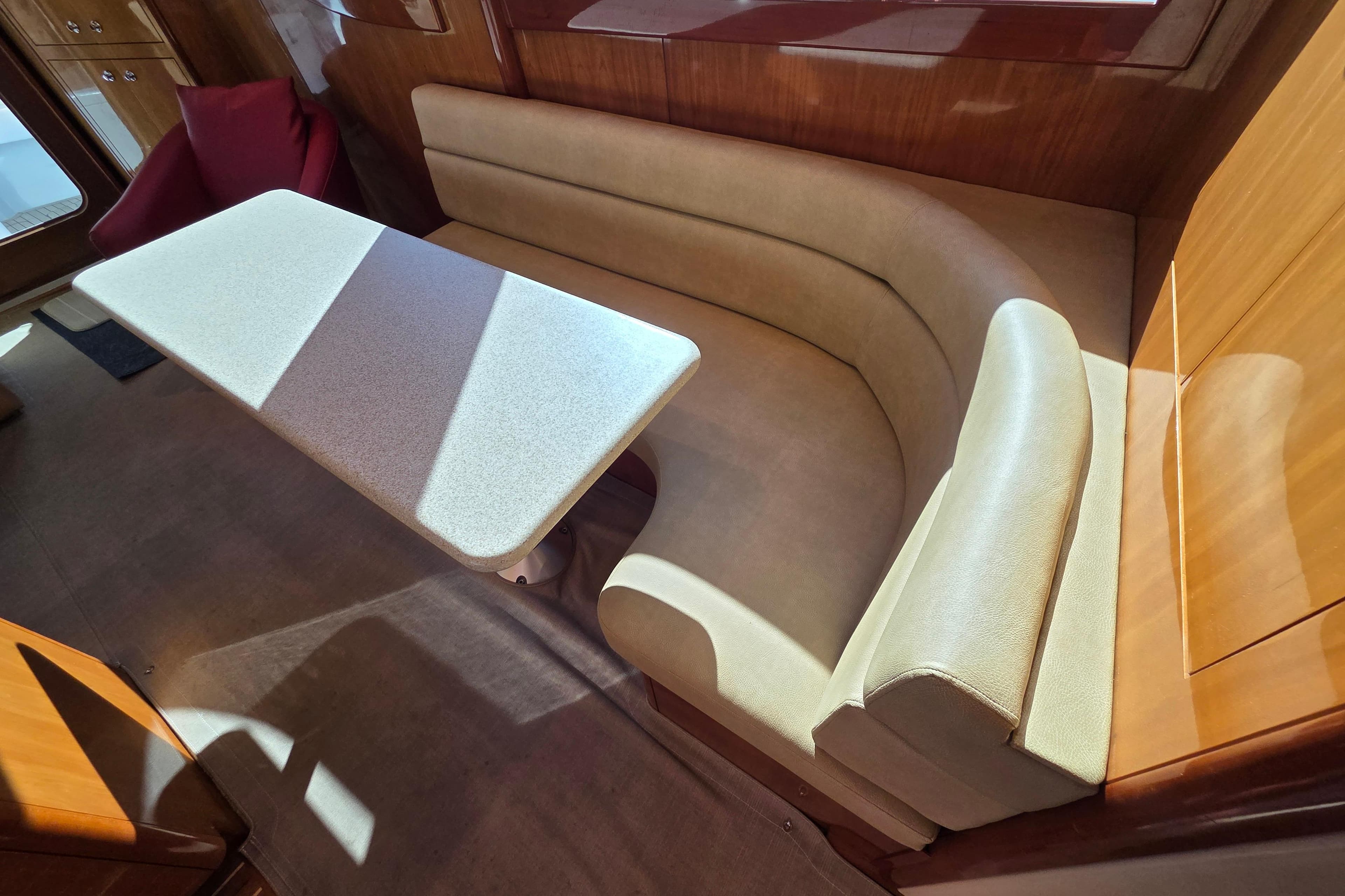 Interior of 2006 Hatteras 50 Convertible yacht with curved seating and table.