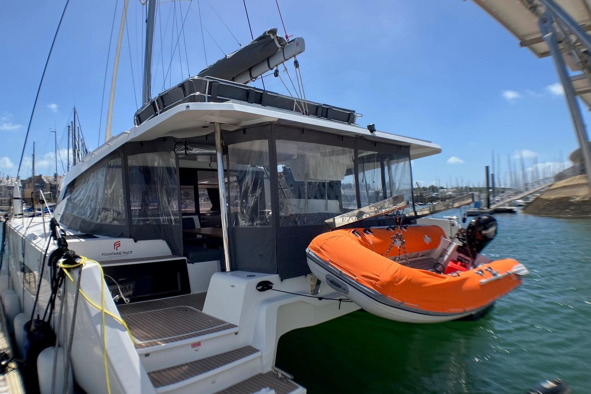 2023 Fountaine Pajot Elba 45 Catamaran docked with orange dinghy attached.