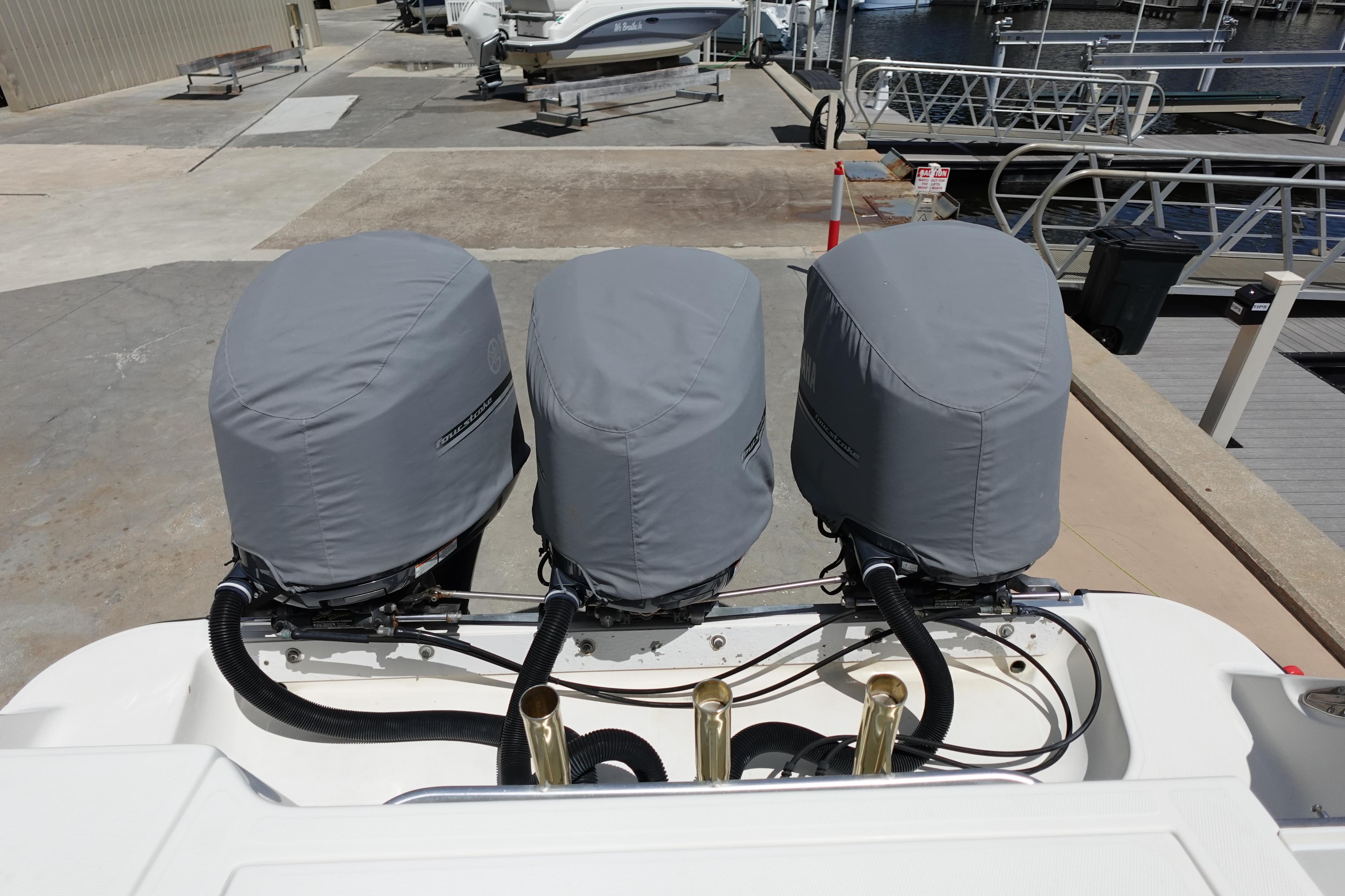 2005 Hydra-Sports Vector 3300 CC with triple covered outboard engines at a marina.