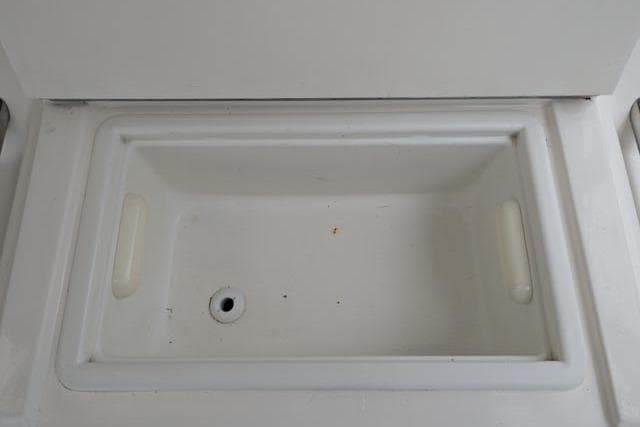 Storage compartment on a 1998 Silverton 402 Motor Yacht, featuring a built-in drain.