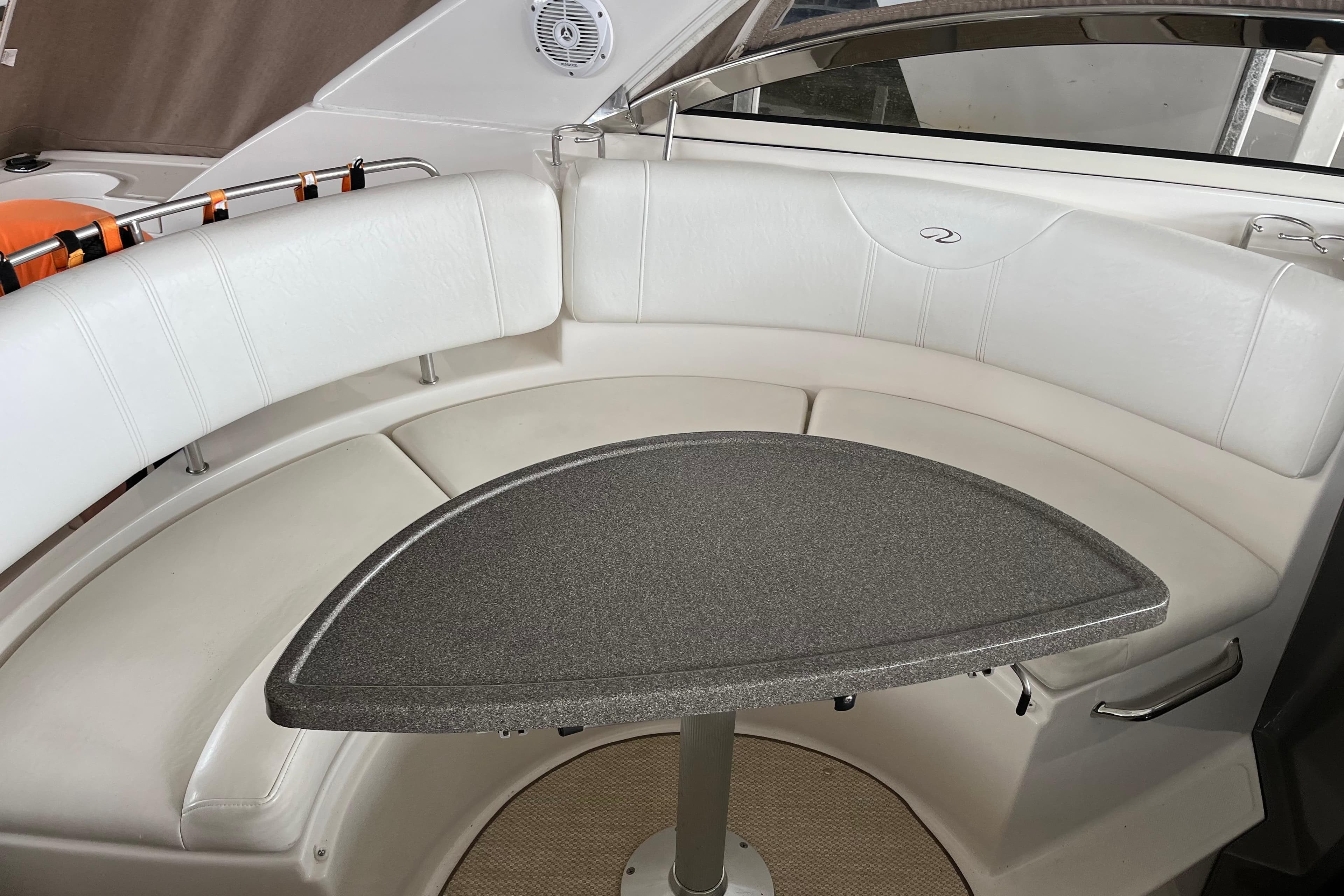2007 Regal 3760 IB Commodore boat interior with white seating and triangular table.