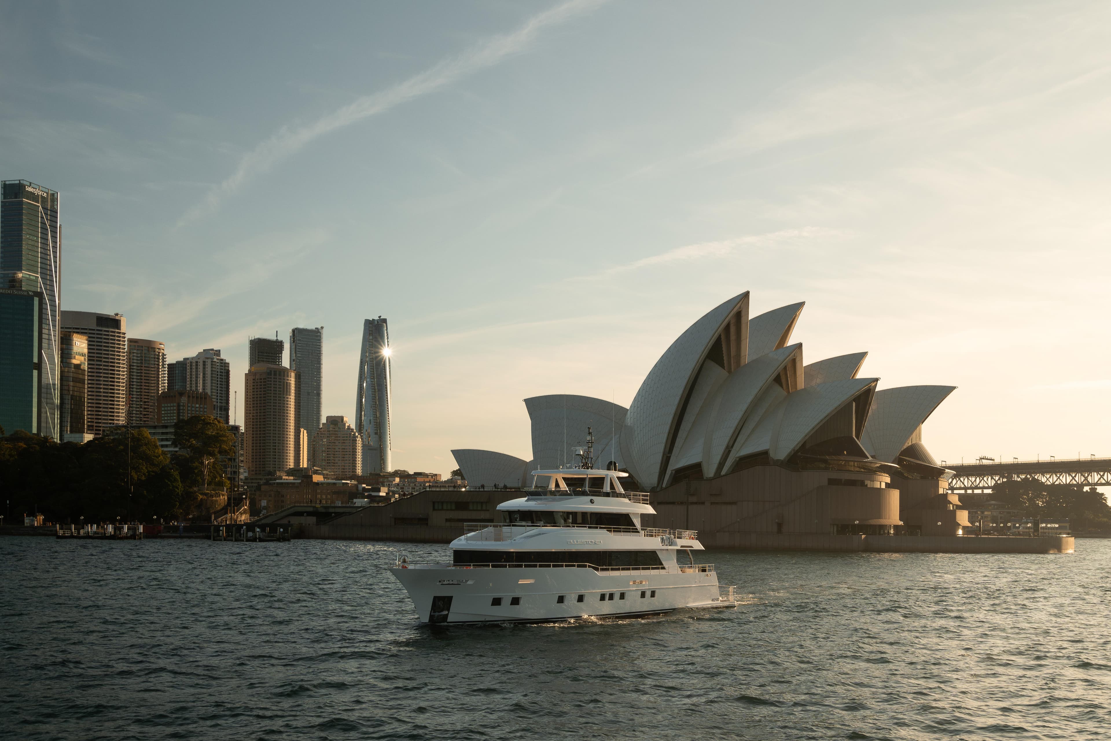 2023 Gulf Craft Nomad yacht cruising near Sydney Opera House at sunset.