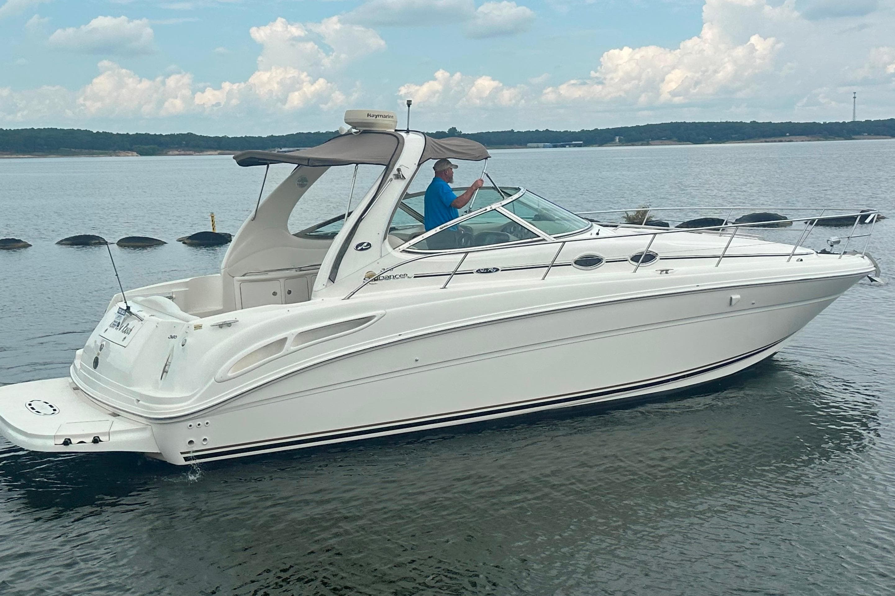2002 Sea Ray 360 Sundancer boat on calm water with a person at the helm.