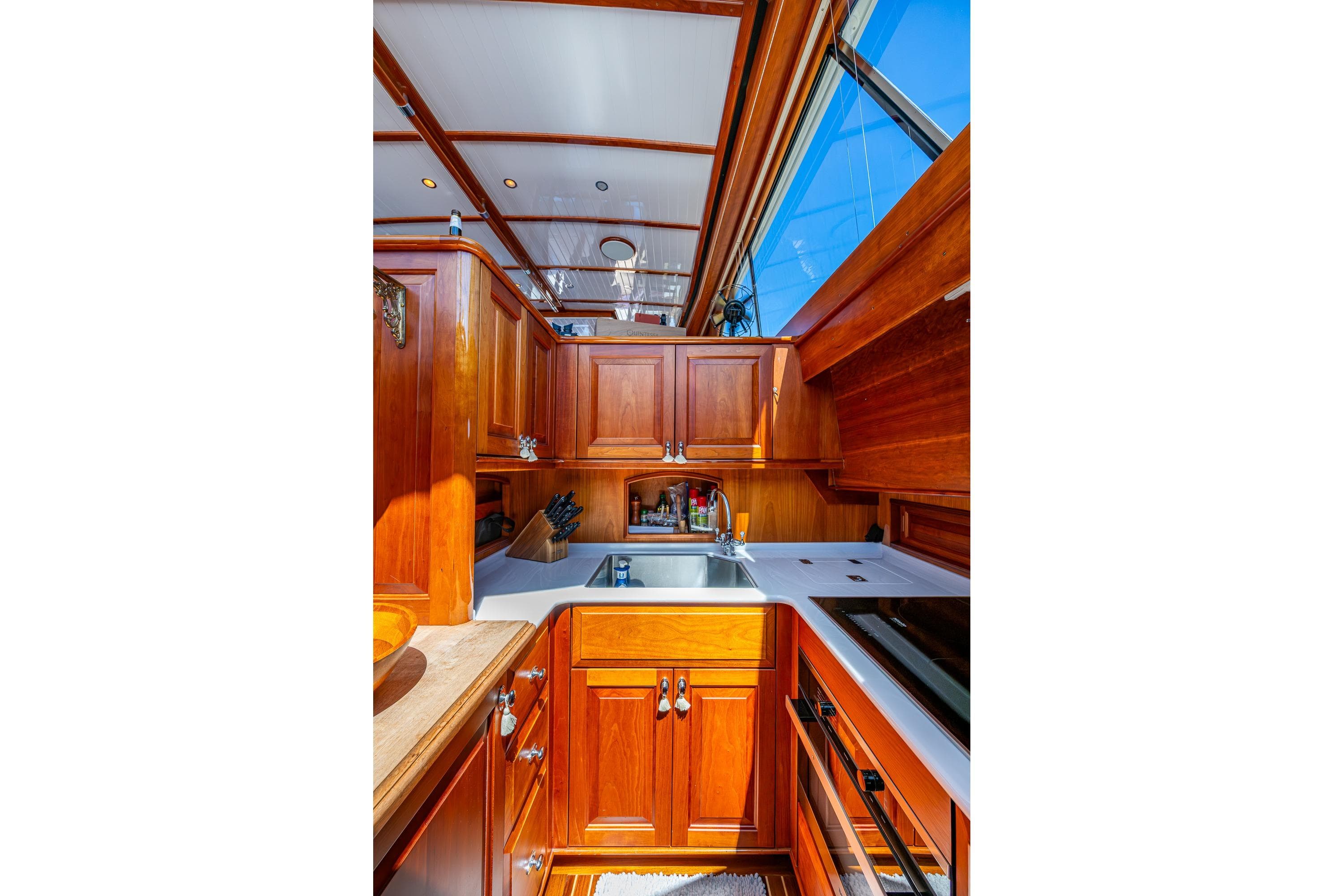 Luxurious 2021 Hinckley Talaria yacht kitchen with elegant wood cabinetry and modern appliances.