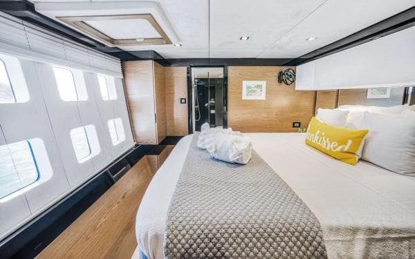 Luxurious Sunreef 60 LOFT 2016 yacht bedroom with modern decor and large windows.