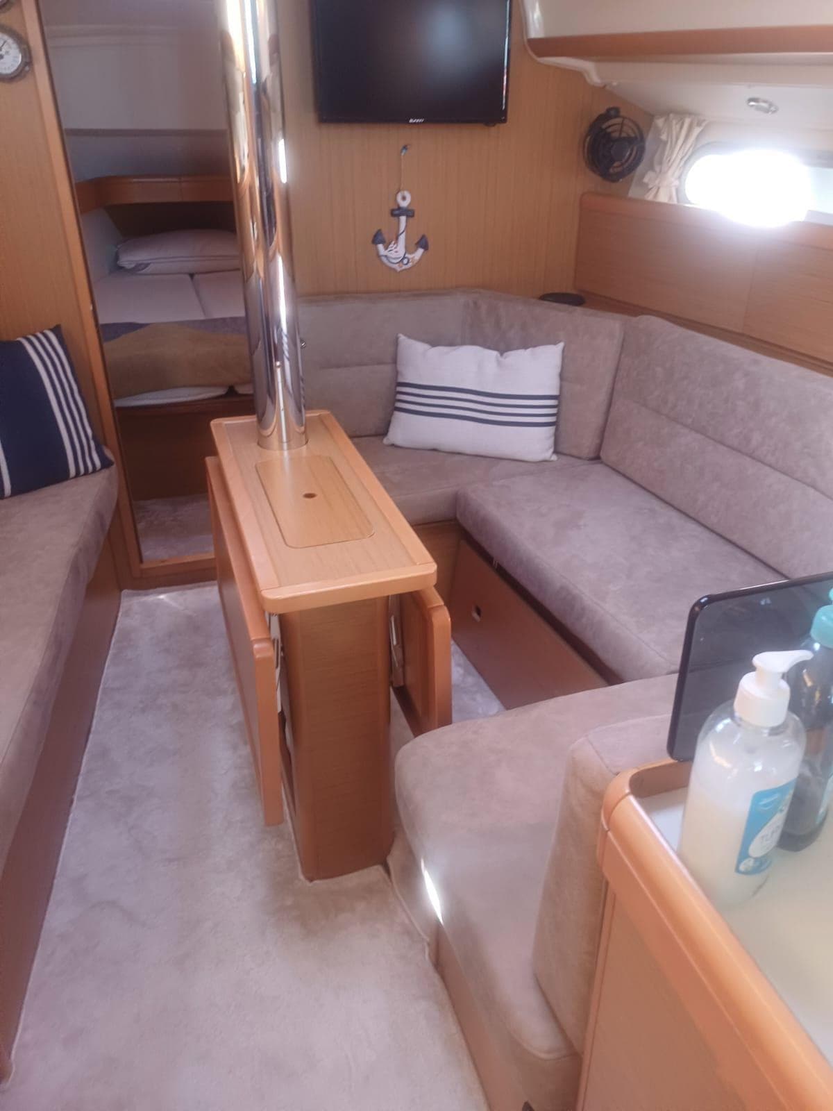 Interior of 2010 Jeanneau Sun Odyssey 36i yacht with cozy seating and nautical decor.