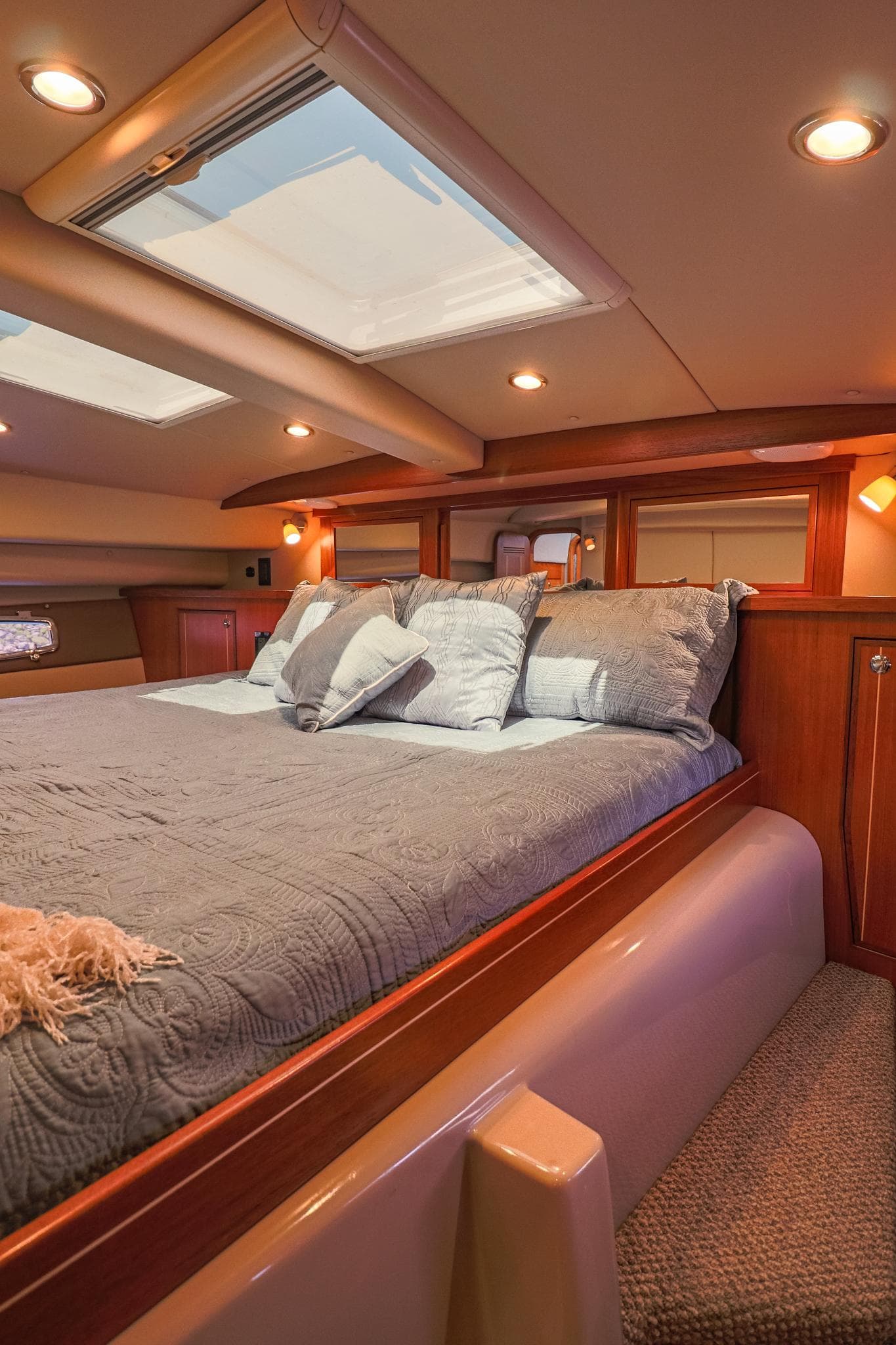 Luxurious cabin interior of 2017 Aspen C120 yacht with skylights and cozy bedding.