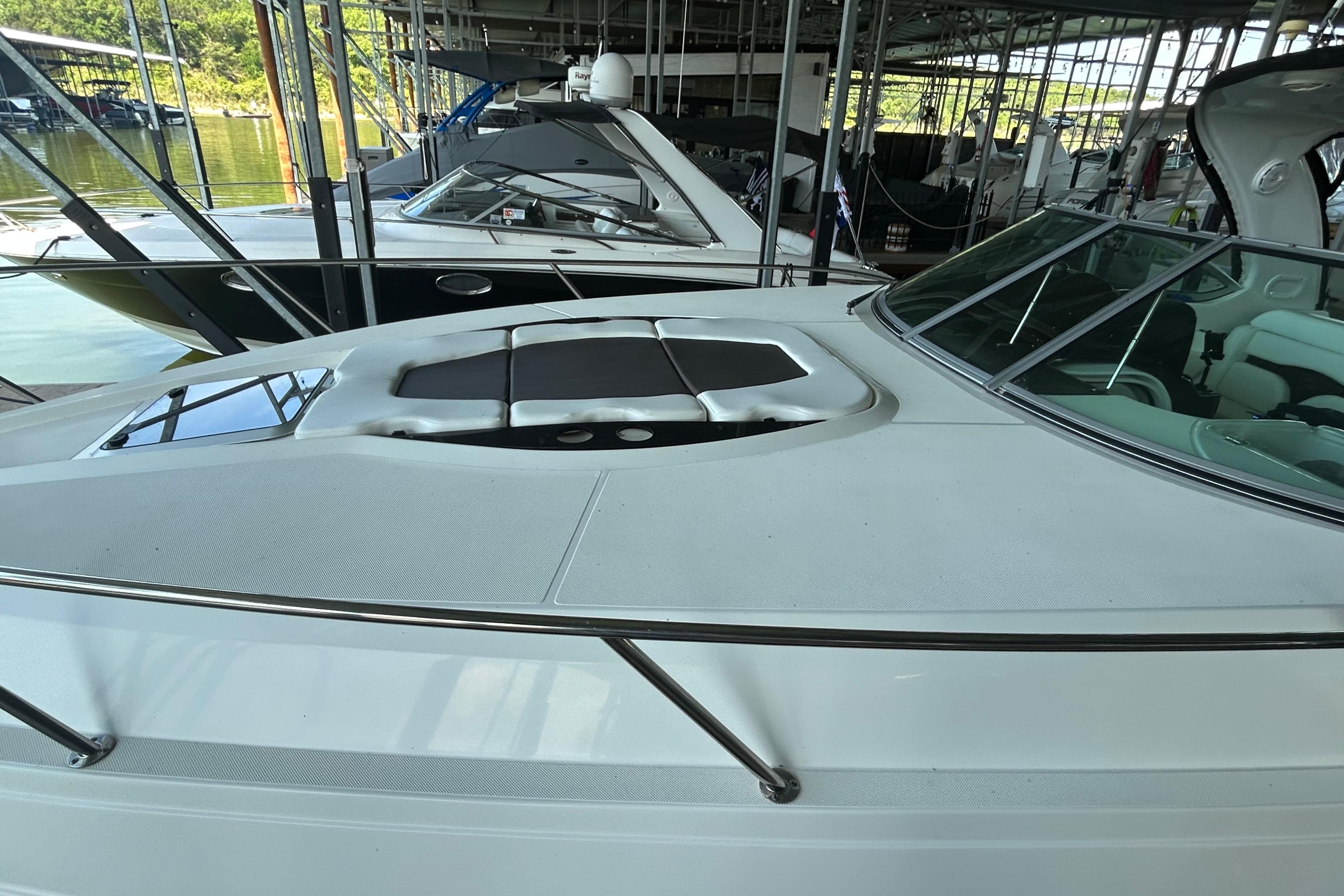 2013 Rinker 310 Express Cruiser docked in a marina, showcasing sleek design and spacious deck.