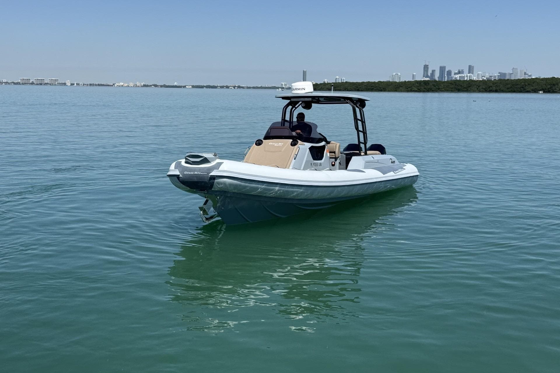 2026 Ranieri Cayman Executive boat on calm water with city skyline in background.