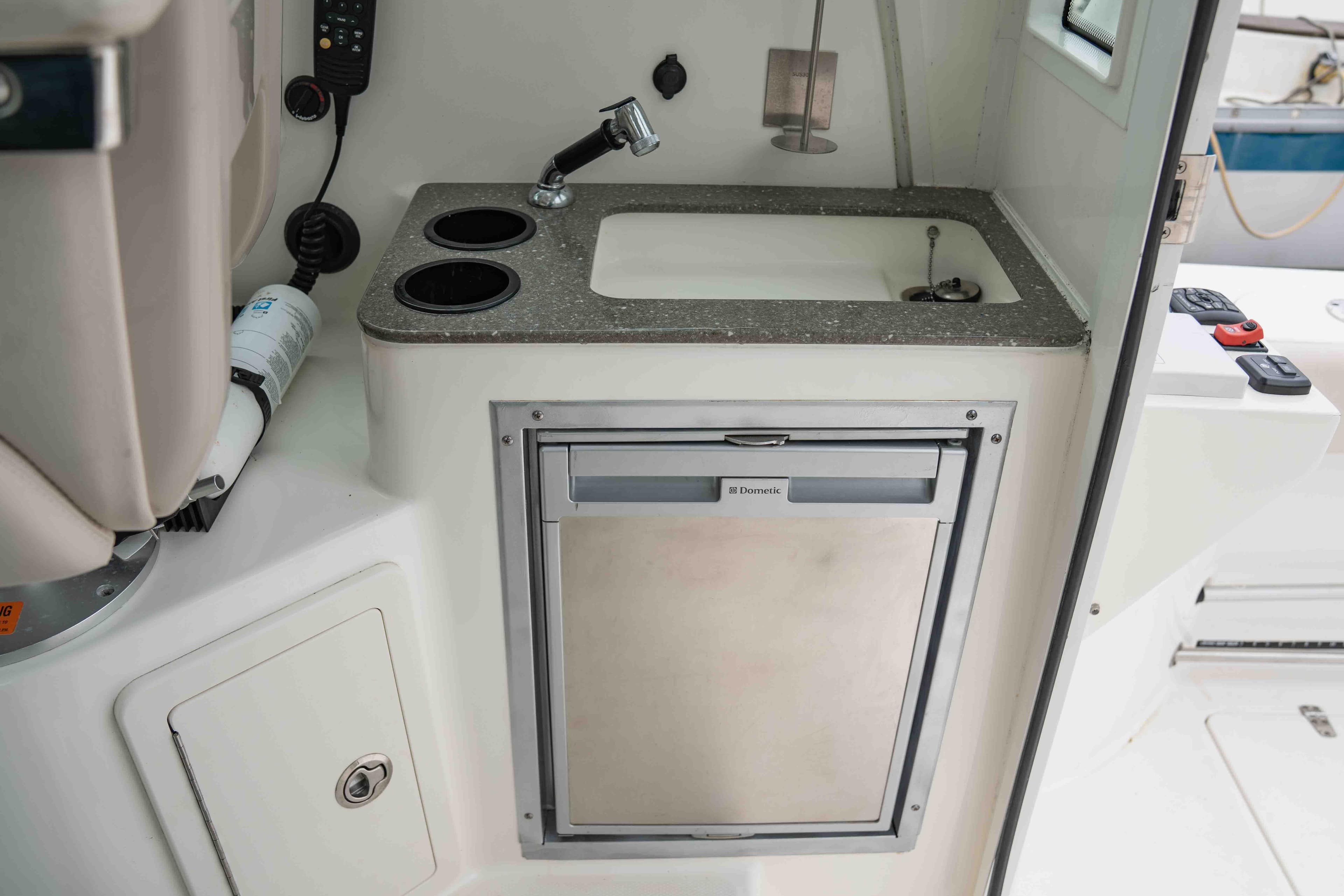 2015 Boston Whaler 315 Conquest Pilothouse kitchenette with sink and Dometic fridge.
