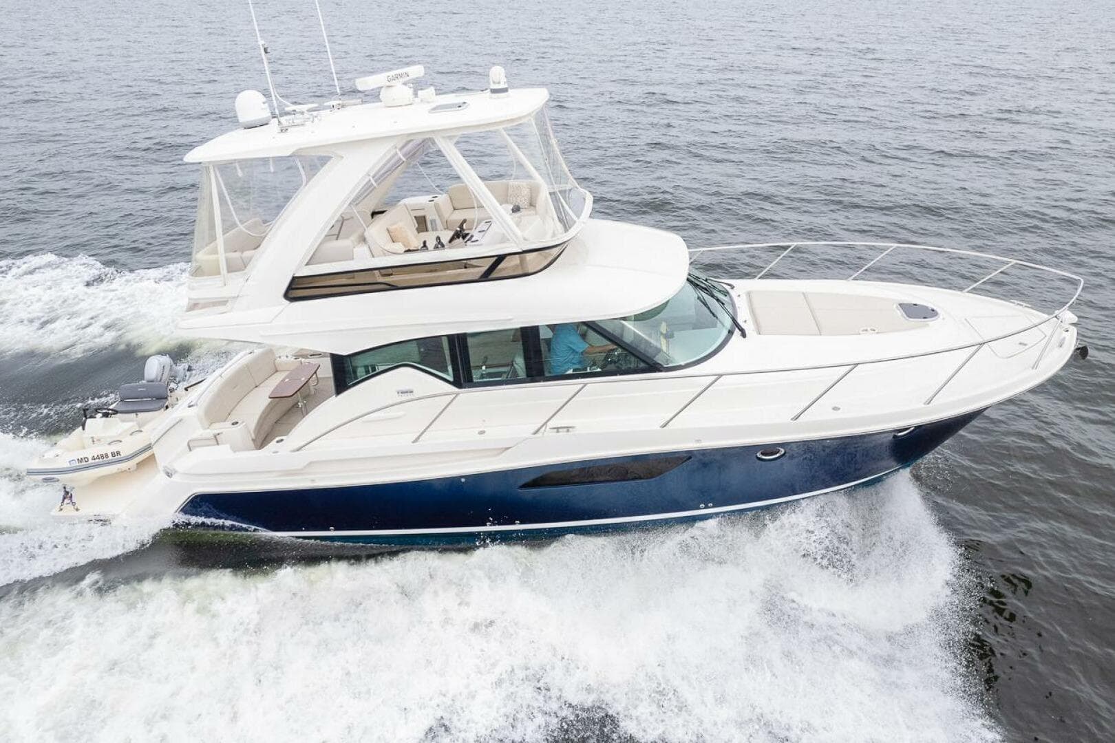 2021 Tiara Yachts F44 Flybridge cruising on open water, showcasing sleek design and luxury.