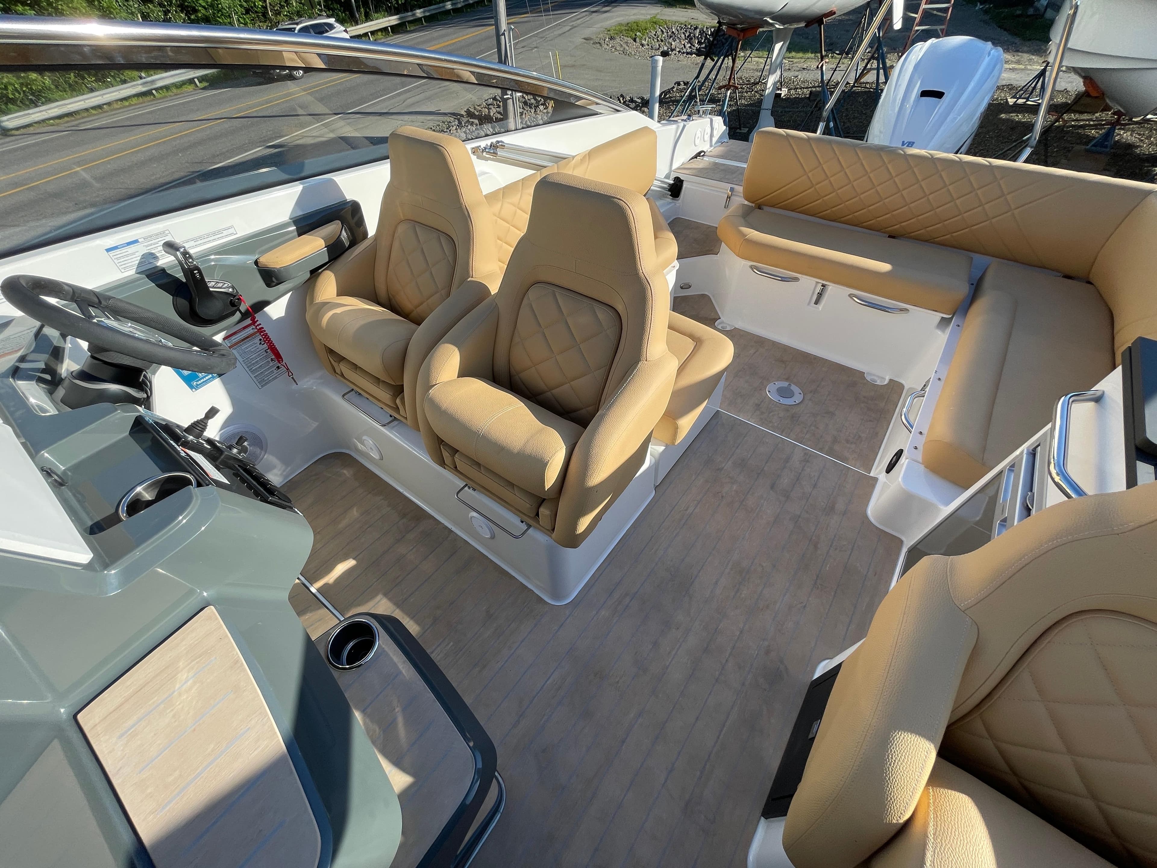Luxurious interior of 2023 Yamarin 88 DC boat with beige seating and modern dashboard.