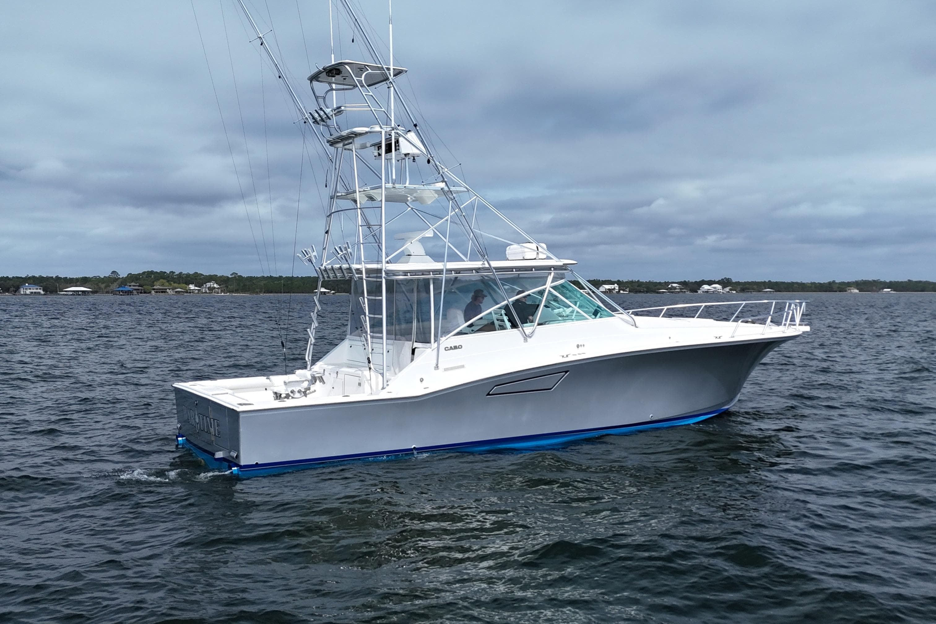 1998 Cabo 45 Express boat on open water under cloudy skies.