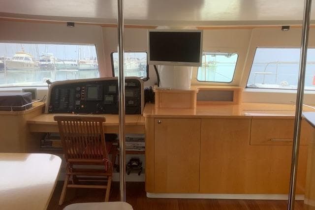 Interior of 2008 Fountaine Pajot Salina 48 catamaran with navigation station and wooden cabinetry.