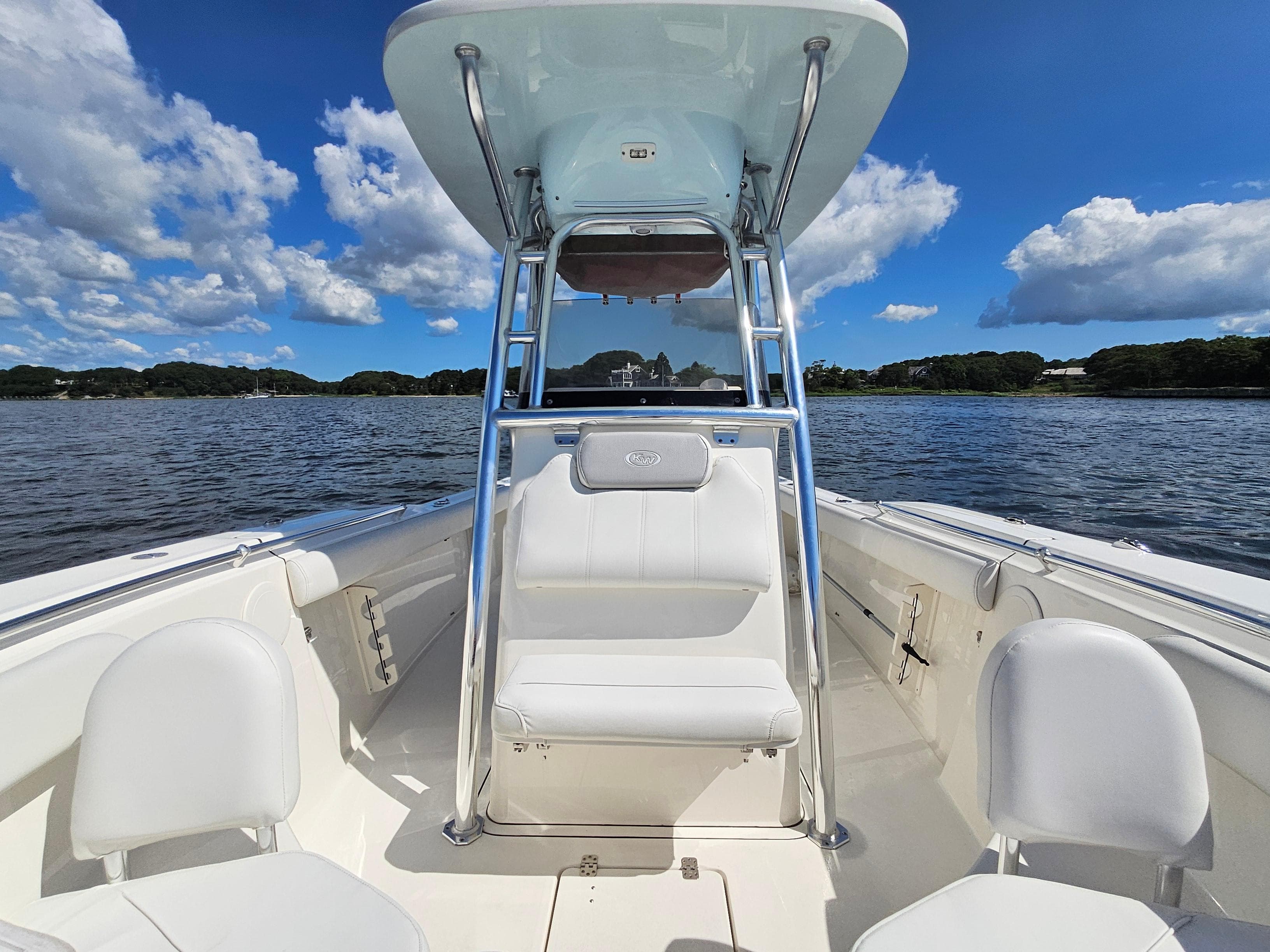 2024 Key West 244 Center Console boat on a sunny day, with blue sky and clouds.