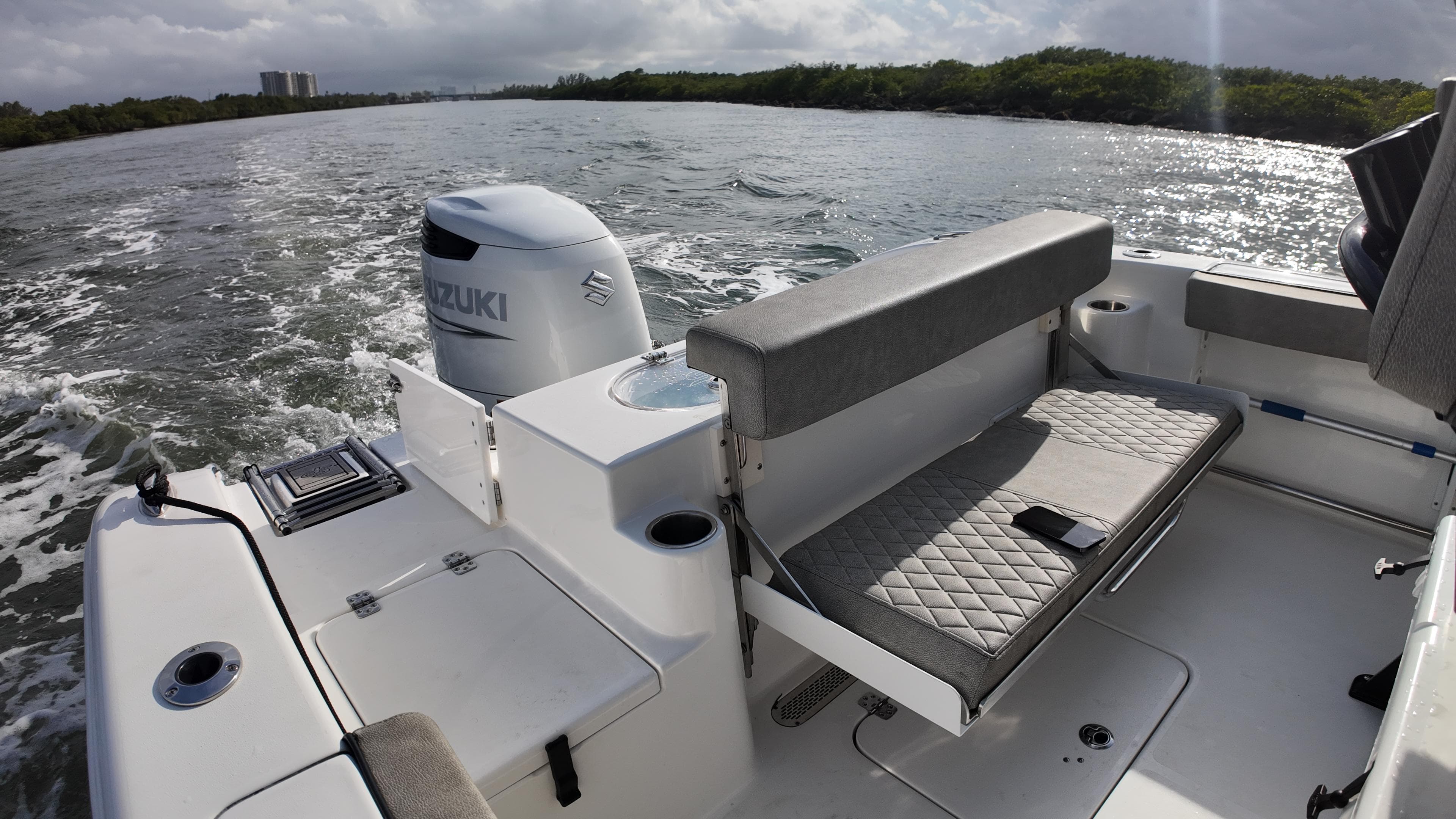 2023 Sea Pro 239 Deluxe CC boat interior with Suzuki engine on a scenic waterway.