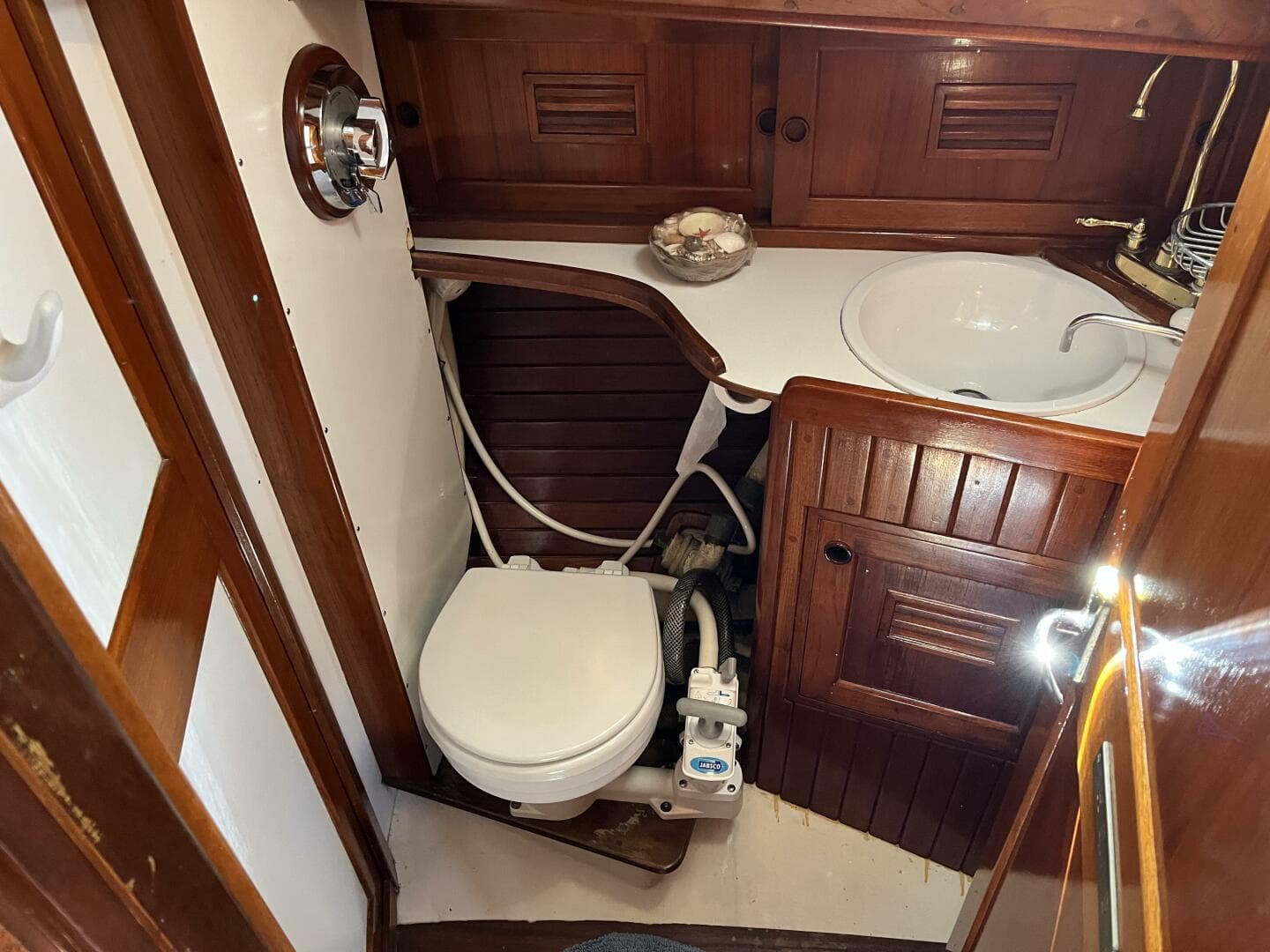 1978 Cheoy Lee Offshore 33 yacht bathroom with wooden cabinetry and compact marine toilet.