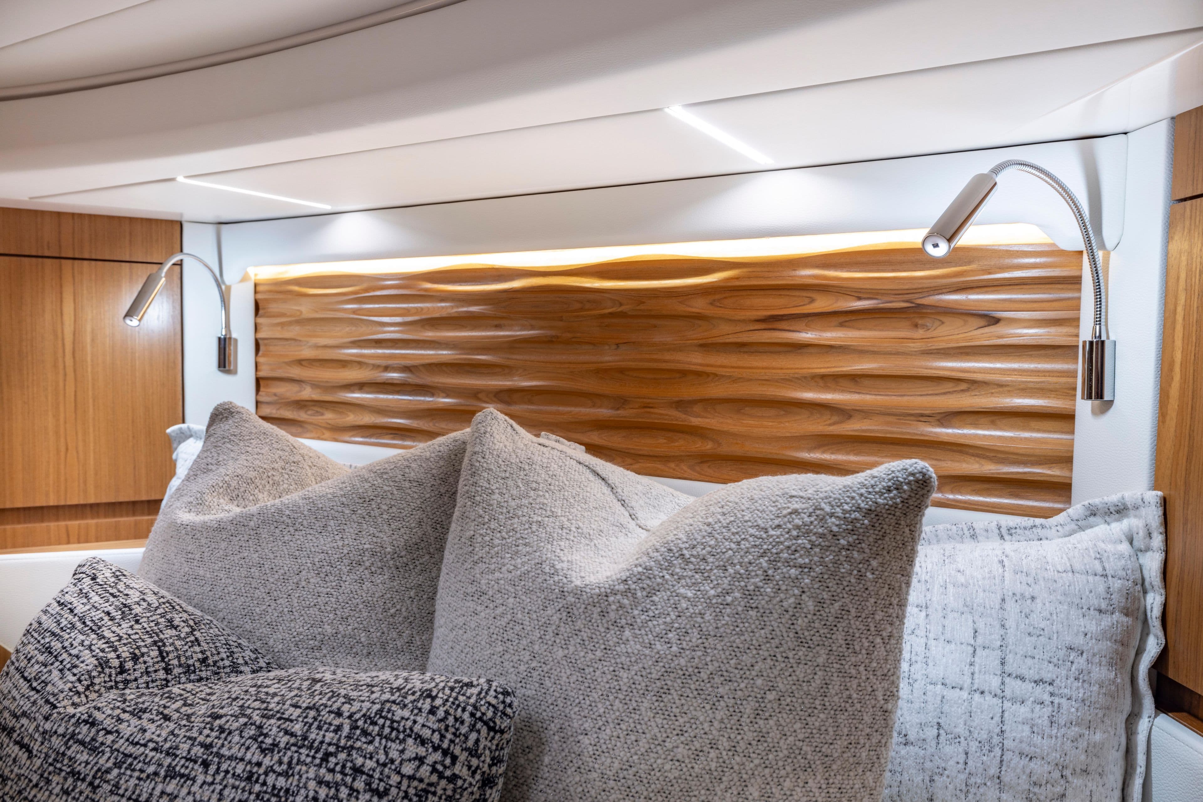 Luxurious 2025 Tiara Yachts EX 54 cabin with elegant wood paneling and plush pillows.
