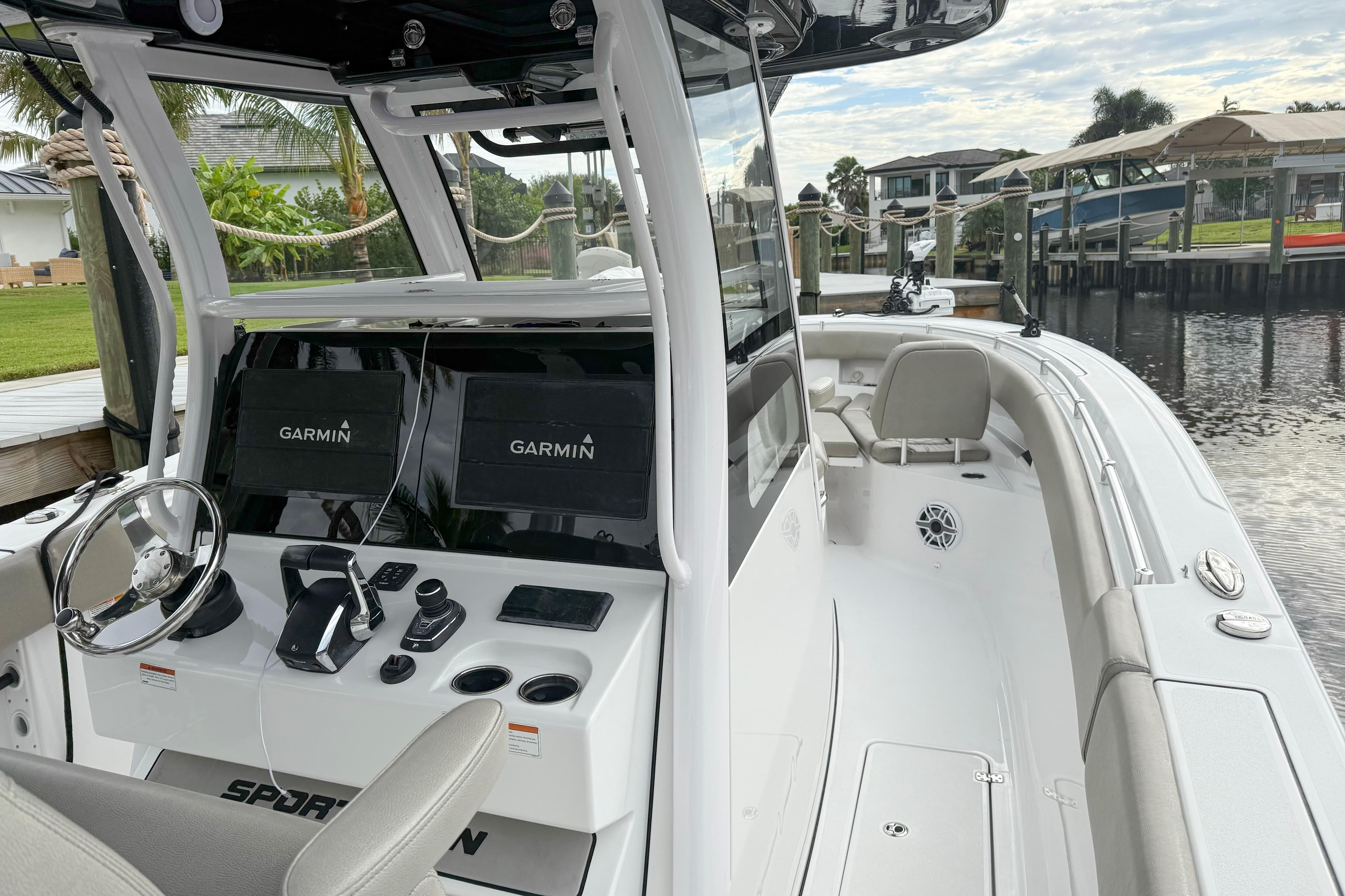 2023 Sportsman Open 322 Center Console boat with Garmin navigation, docked by a waterfront.