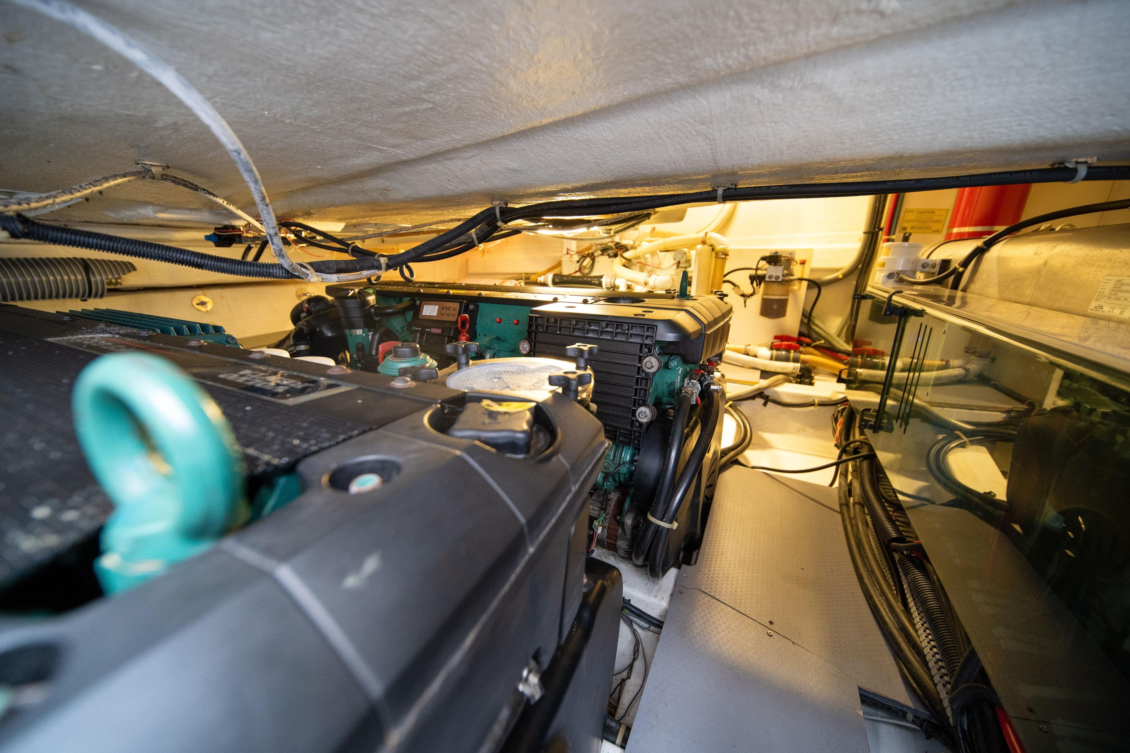 Engine room of 2010 Beneteau Monte Carlo 47 yacht, showcasing mechanical components and wiring.