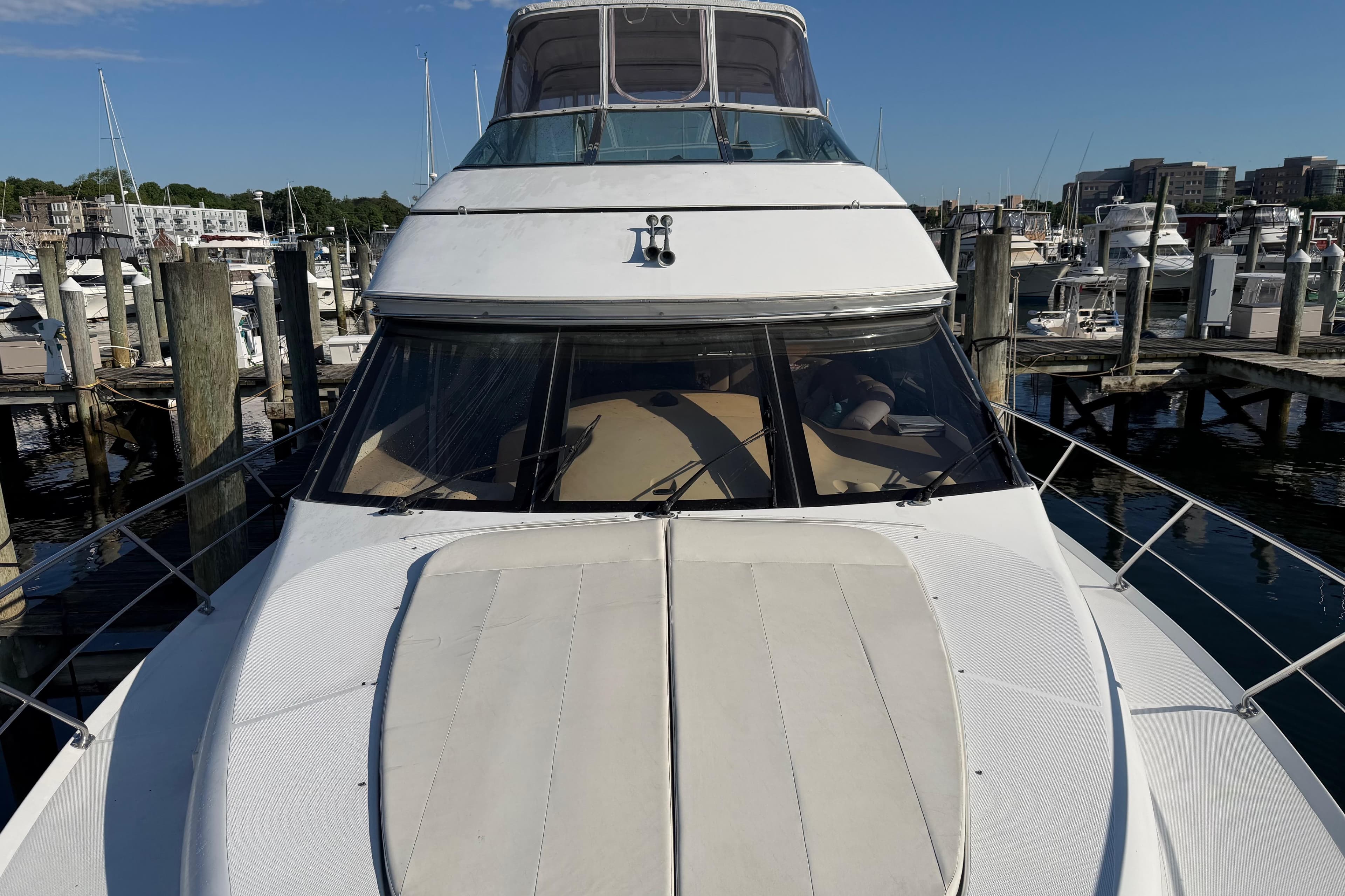 1999 Carver 530 Voyager Pilothouse yacht docked at a marina under clear blue skies.
