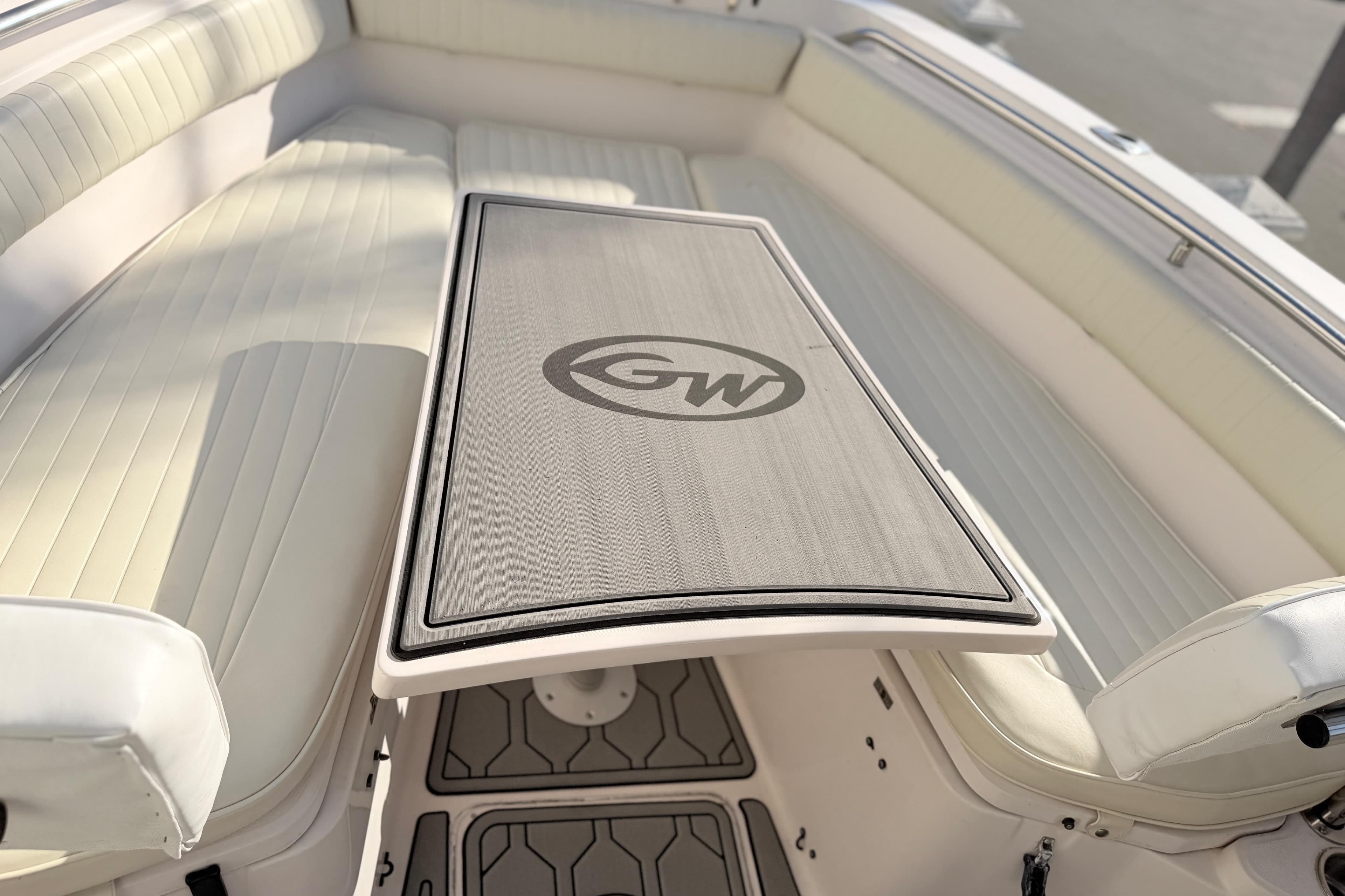 2004 Grady White 273 boat interior with cushioned seating and branded table.