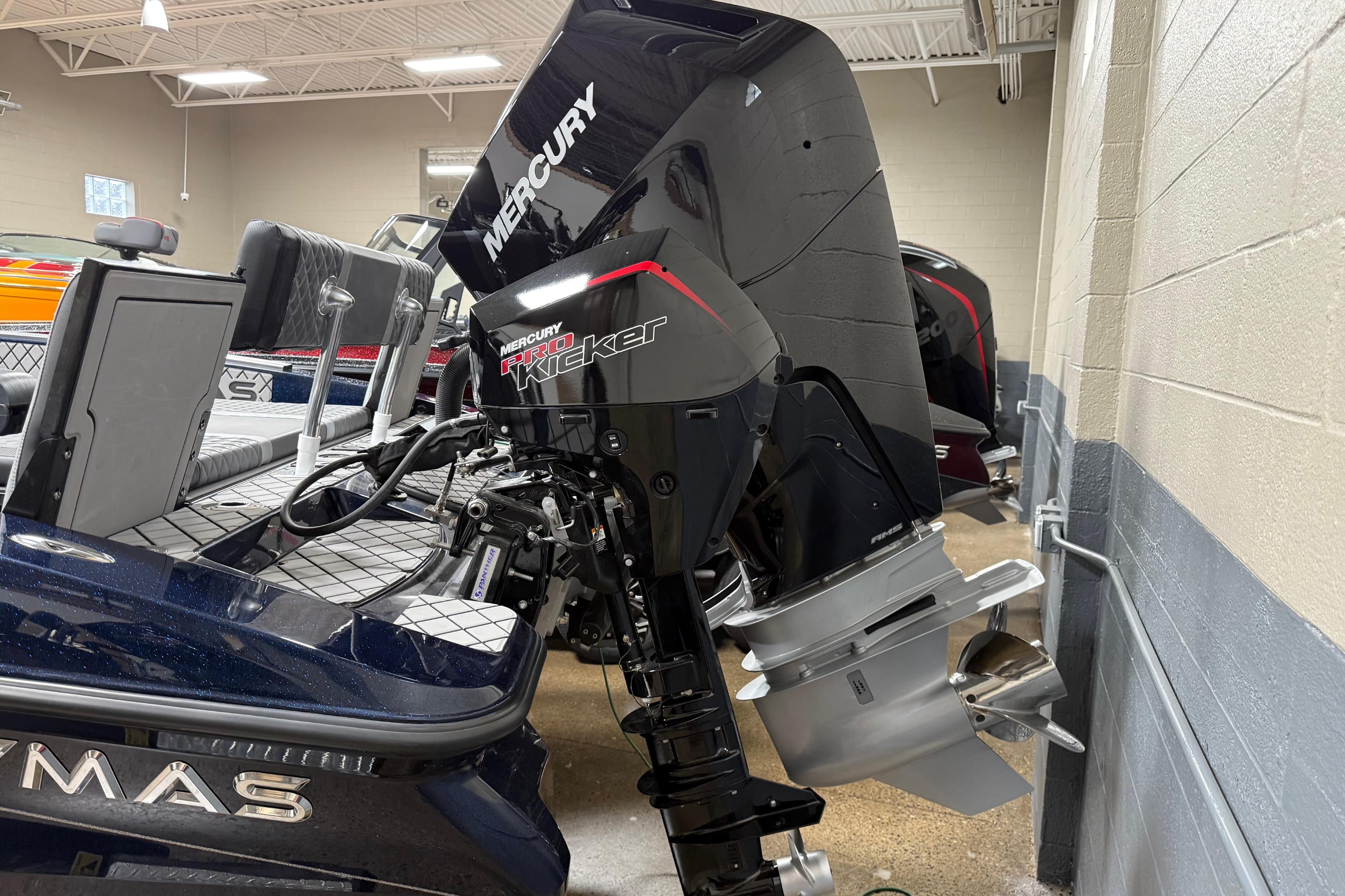 2026 Caymas DV 22 boat with Mercury Pro Kicker outboard motor in showroom.