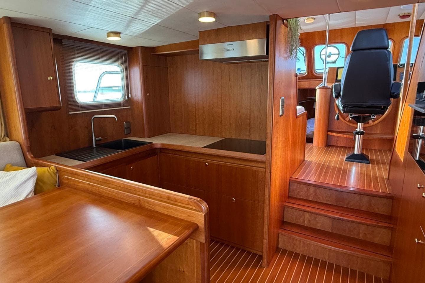 Luxurious 2021 Altena Trawler 50 interior with wooden finishes and modern kitchen.