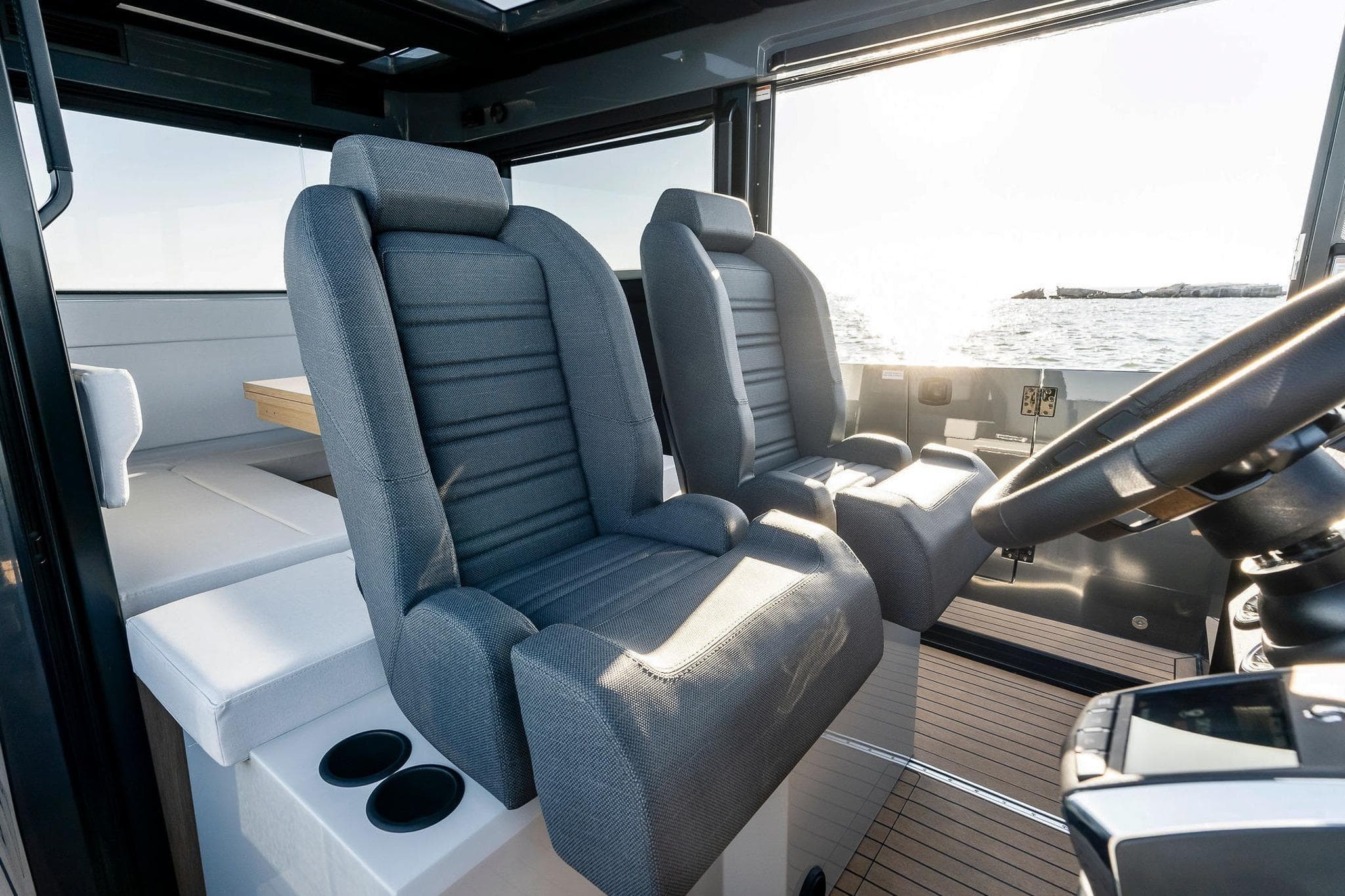 Interior of 2026 XO EXPLR 44 boat with modern seating and steering wheel.